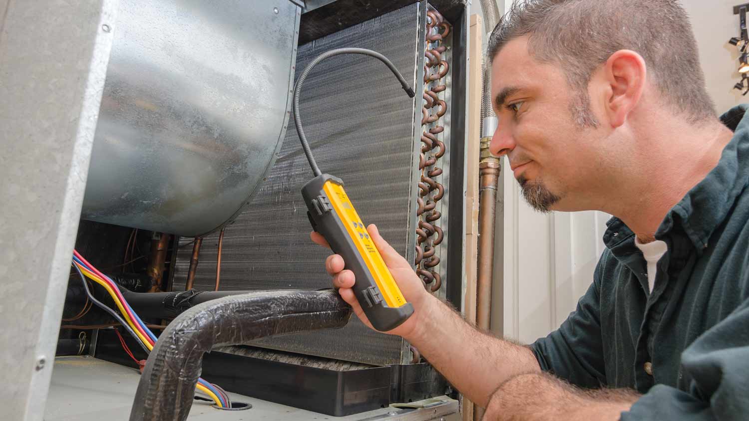 hvac technician with leak detector