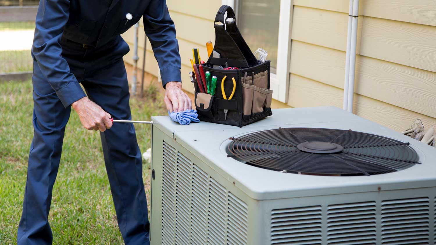 ac technician servicing outdoor unit