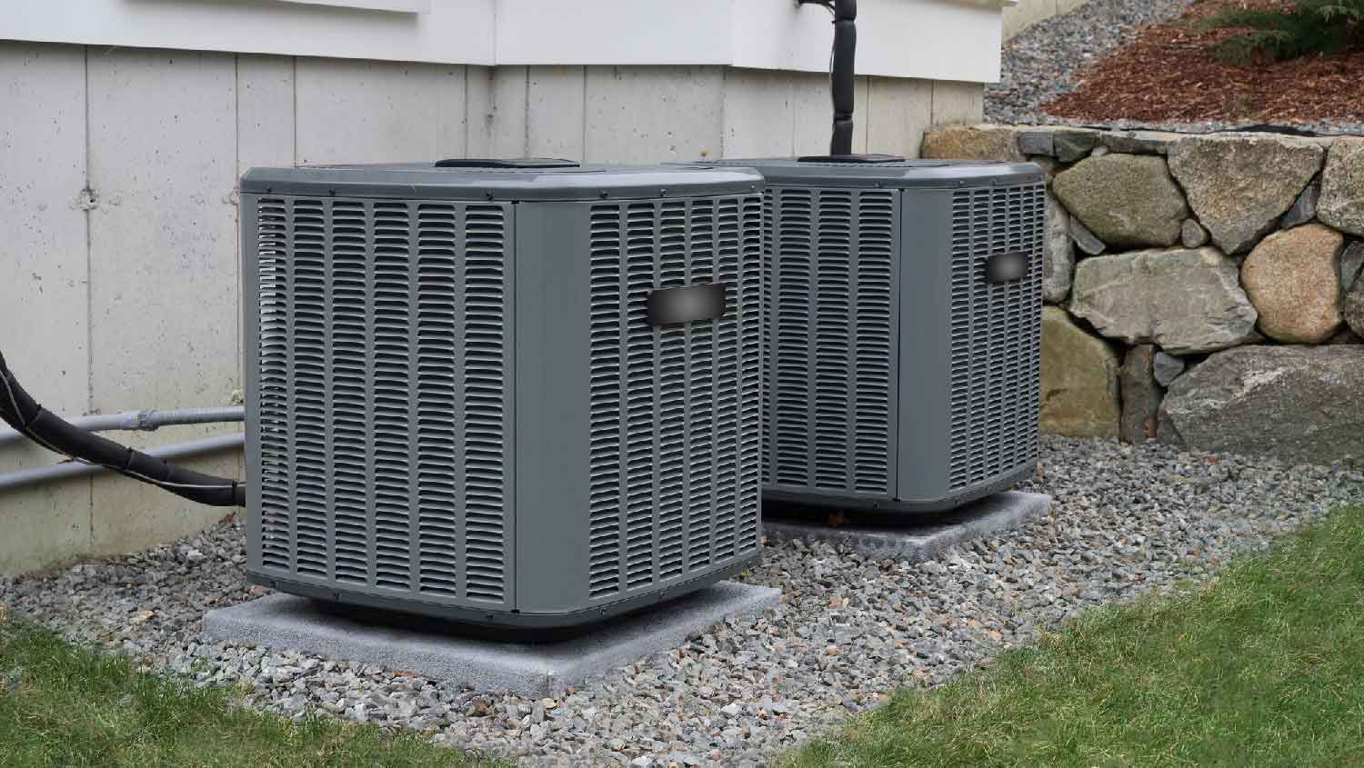 HVAC units next to a stone wall