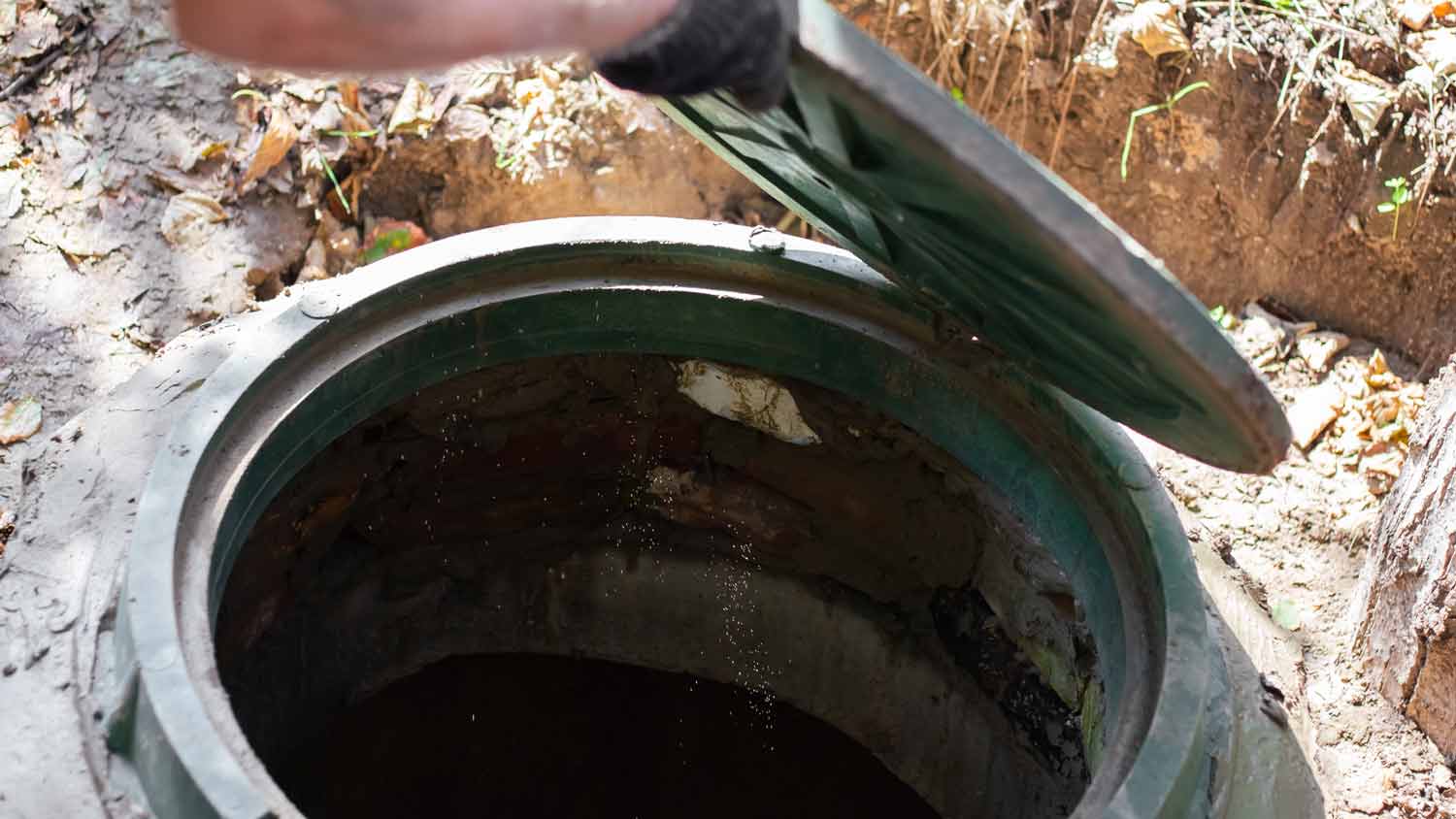 man inspecting septic tank