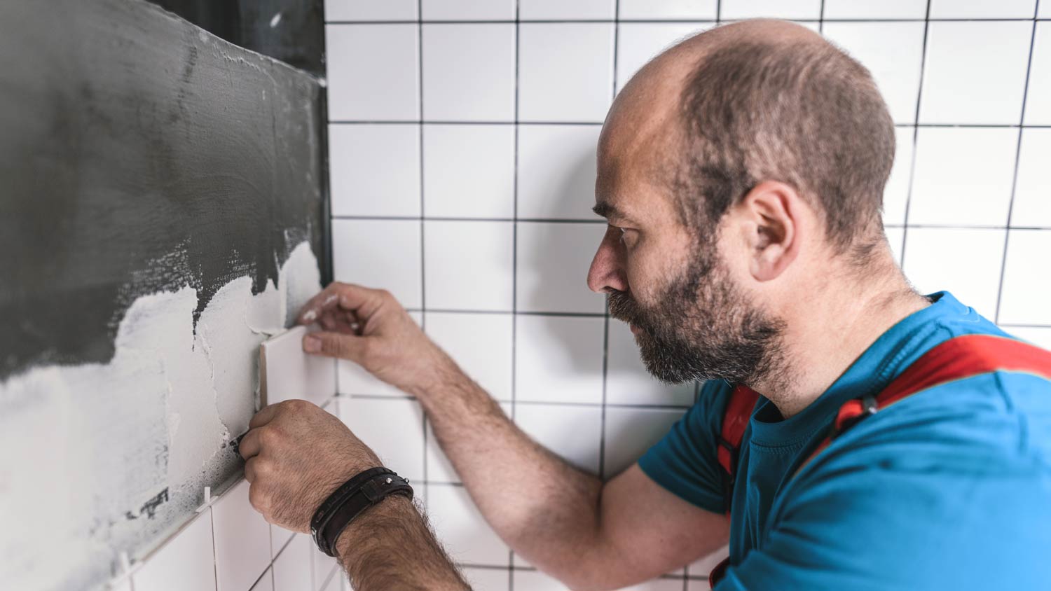 man installing corner tiles