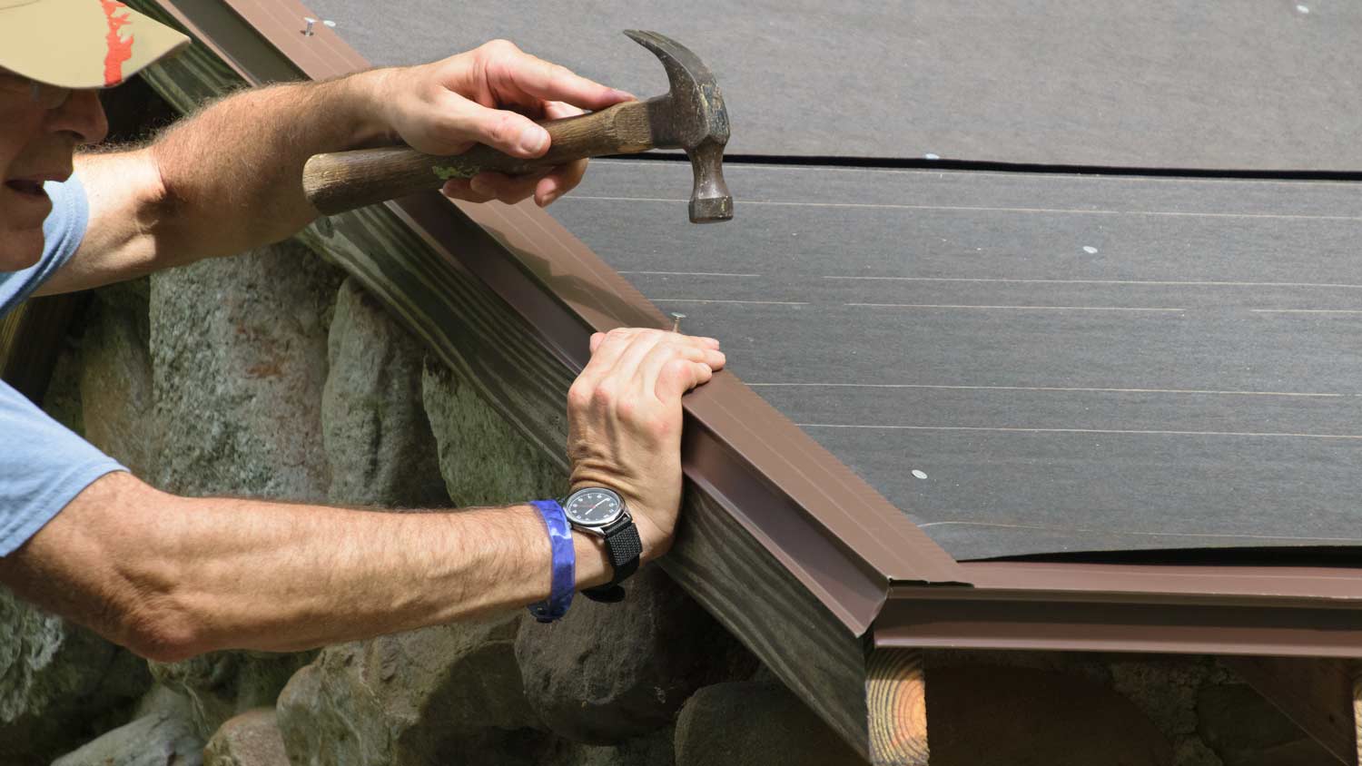 man installing drip edge flashing on roof