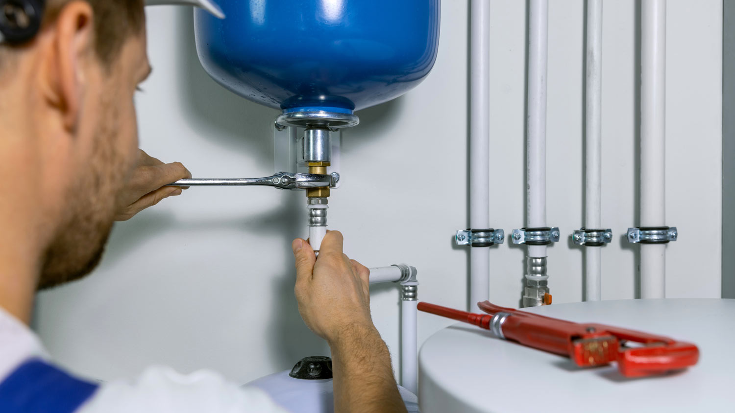 man installing expansion tank on boiler