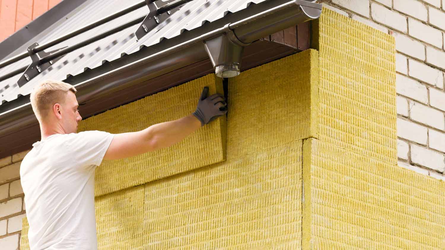 man installing exterior home insulation