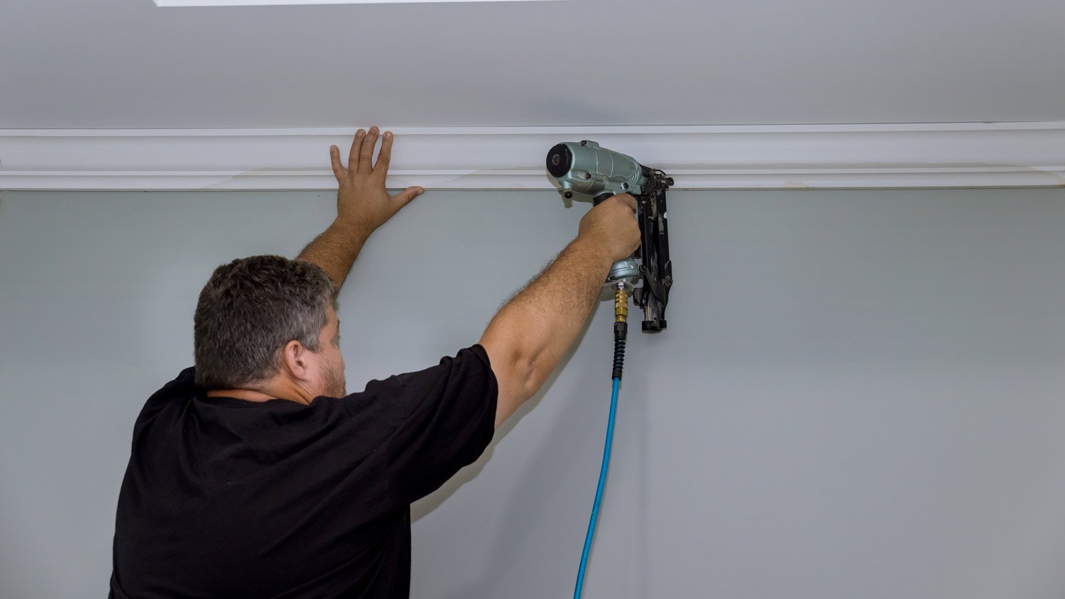 man installing foam crown molding  