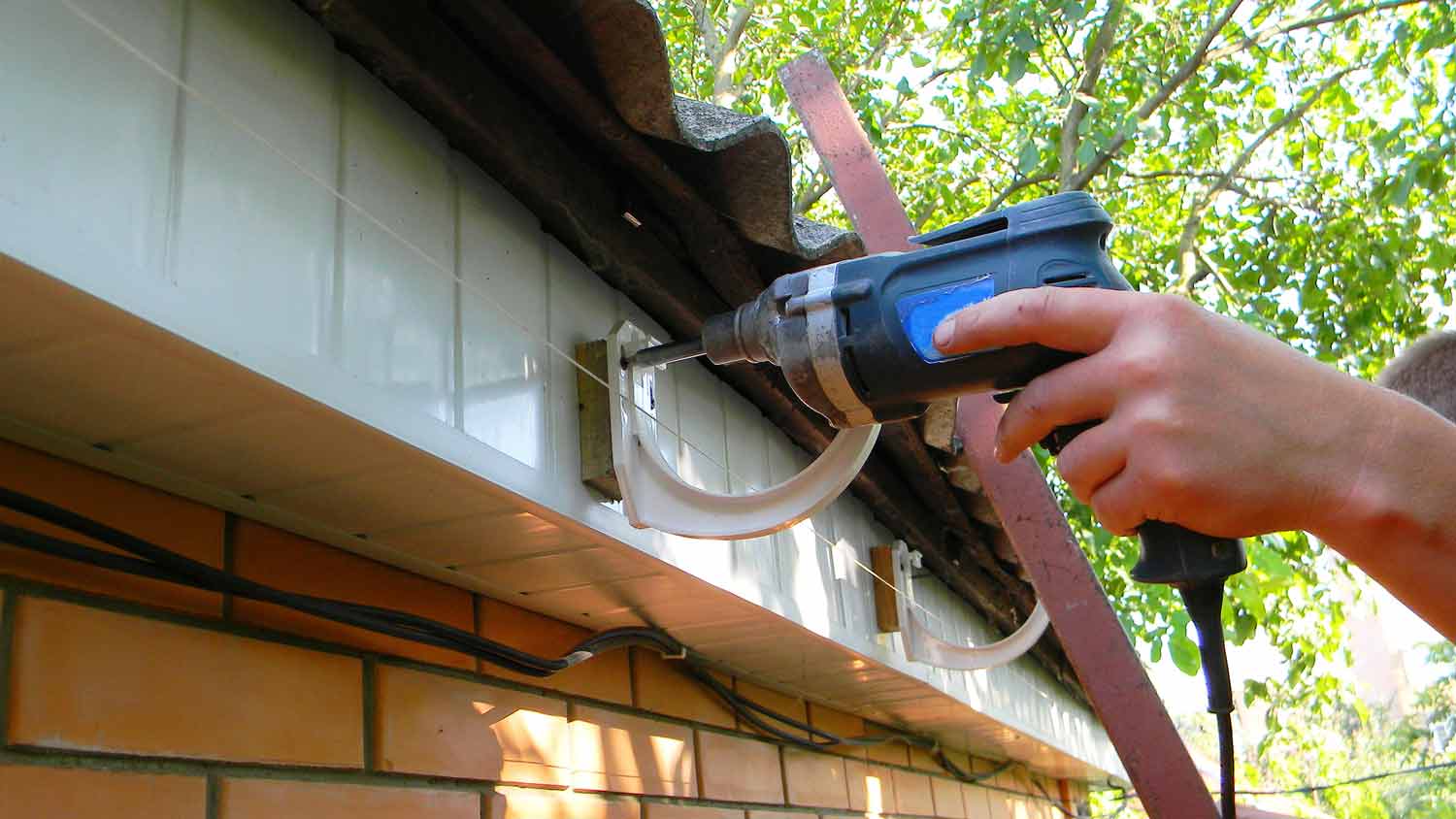 man installing gutter hangers