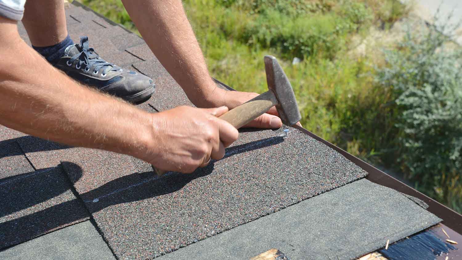 Roofer installing asphalt shingles on the roof