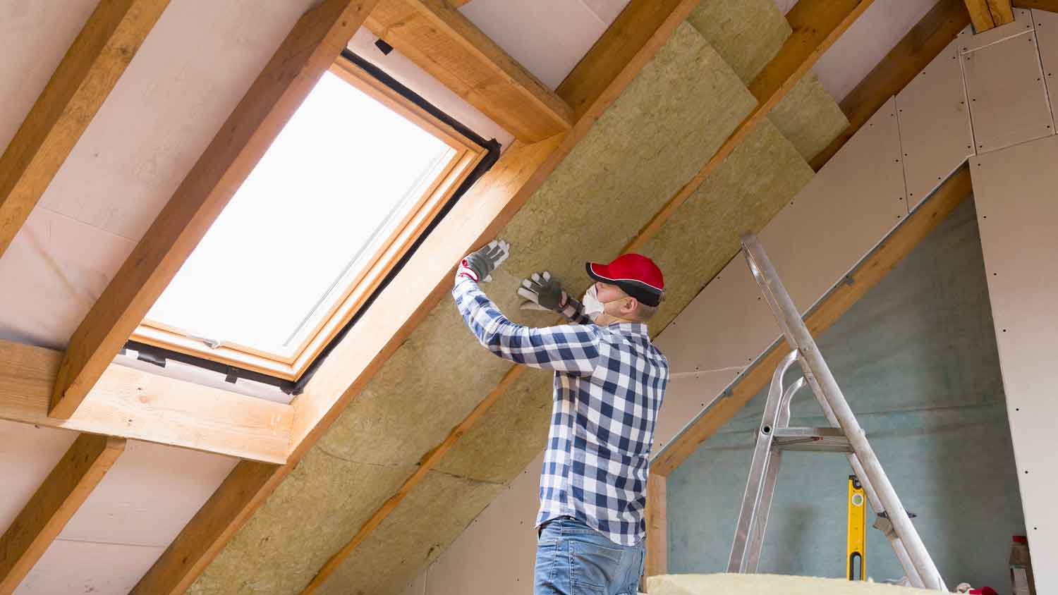 Contractor installing insulation in the attic