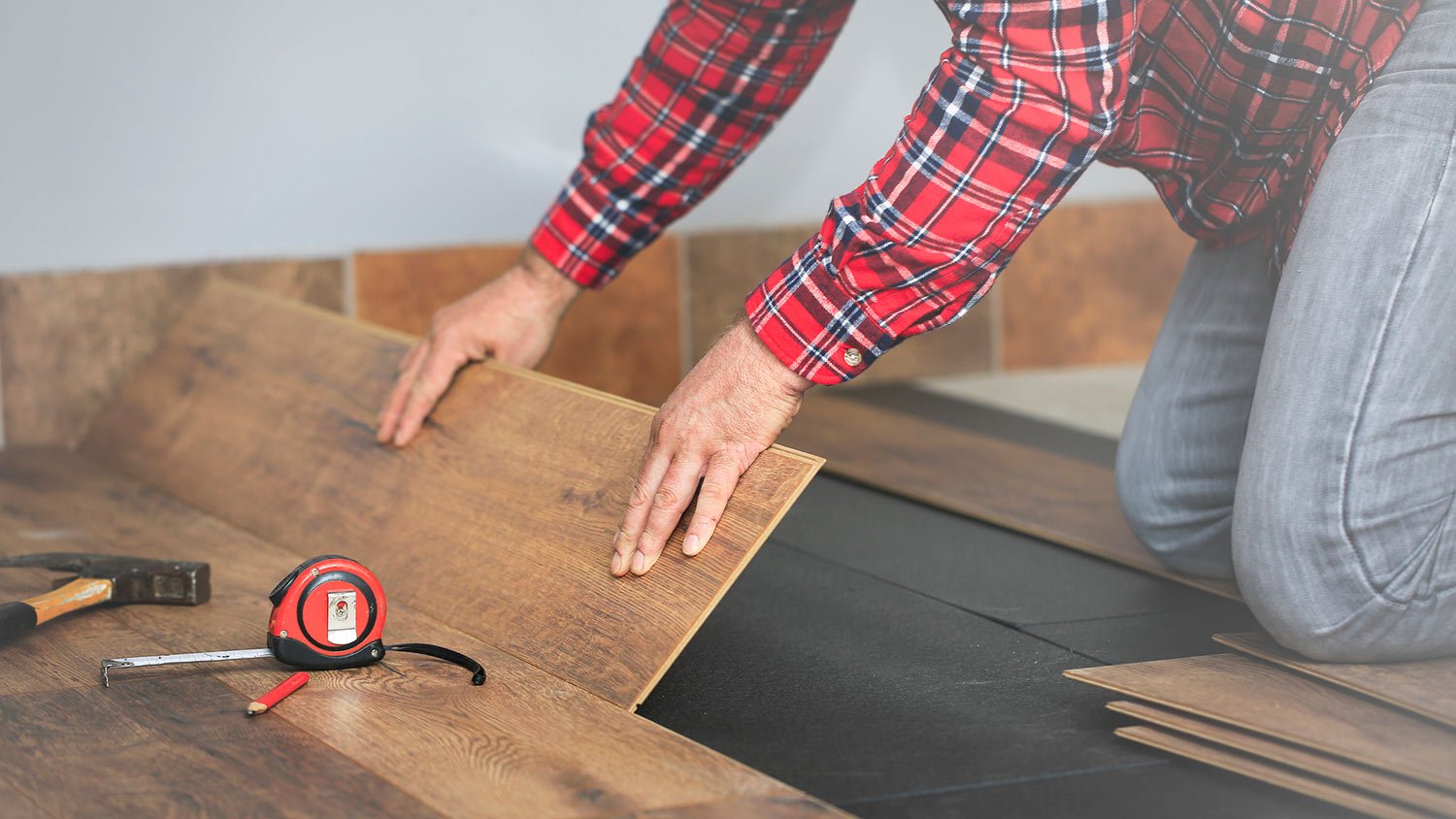 Man installs laminate wood floor