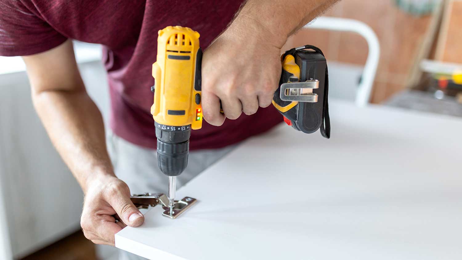 Man installing new kitchen cabinet hinges