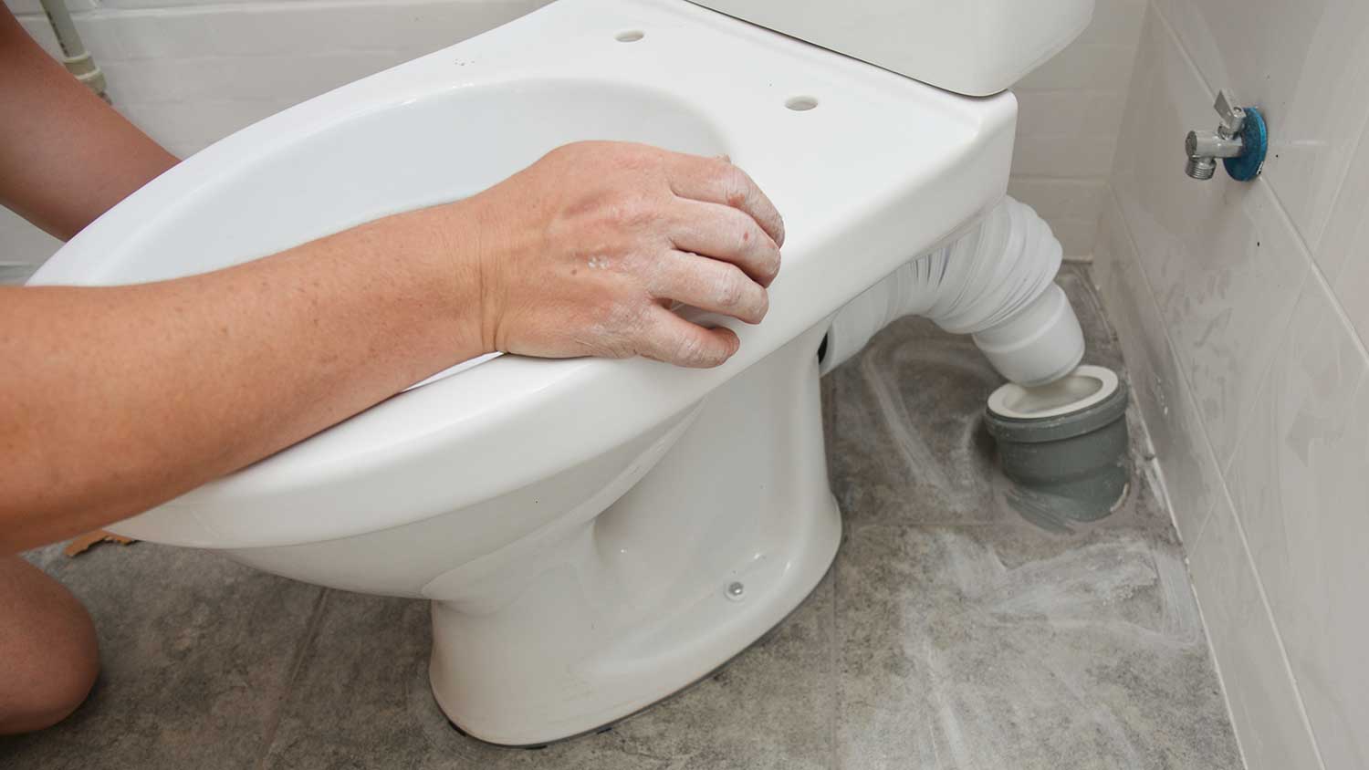 Plumber installing new toilet in the bathroom