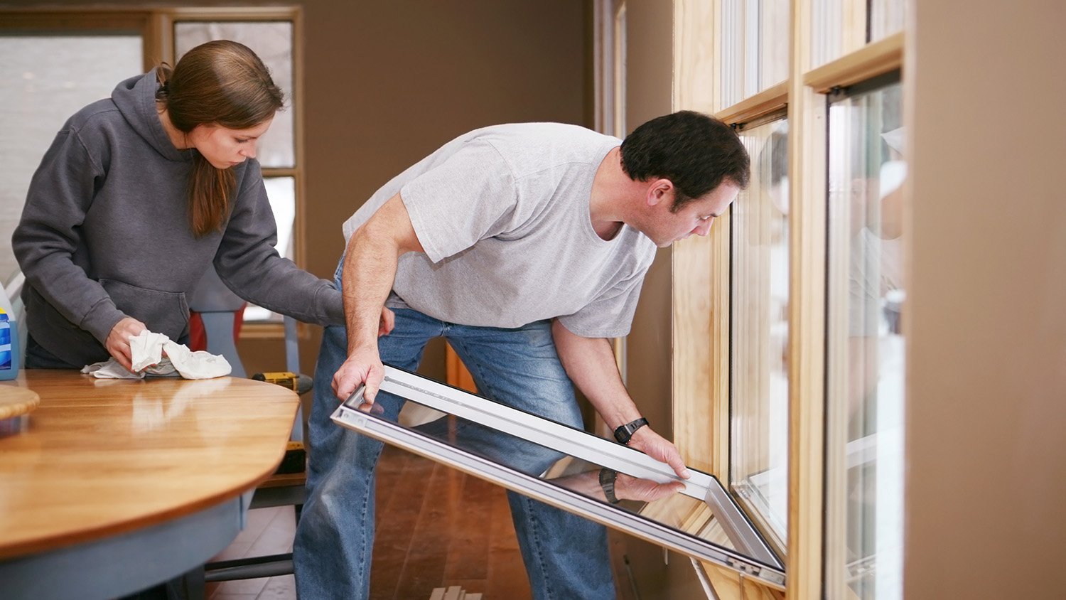 Man and woman installing new windows