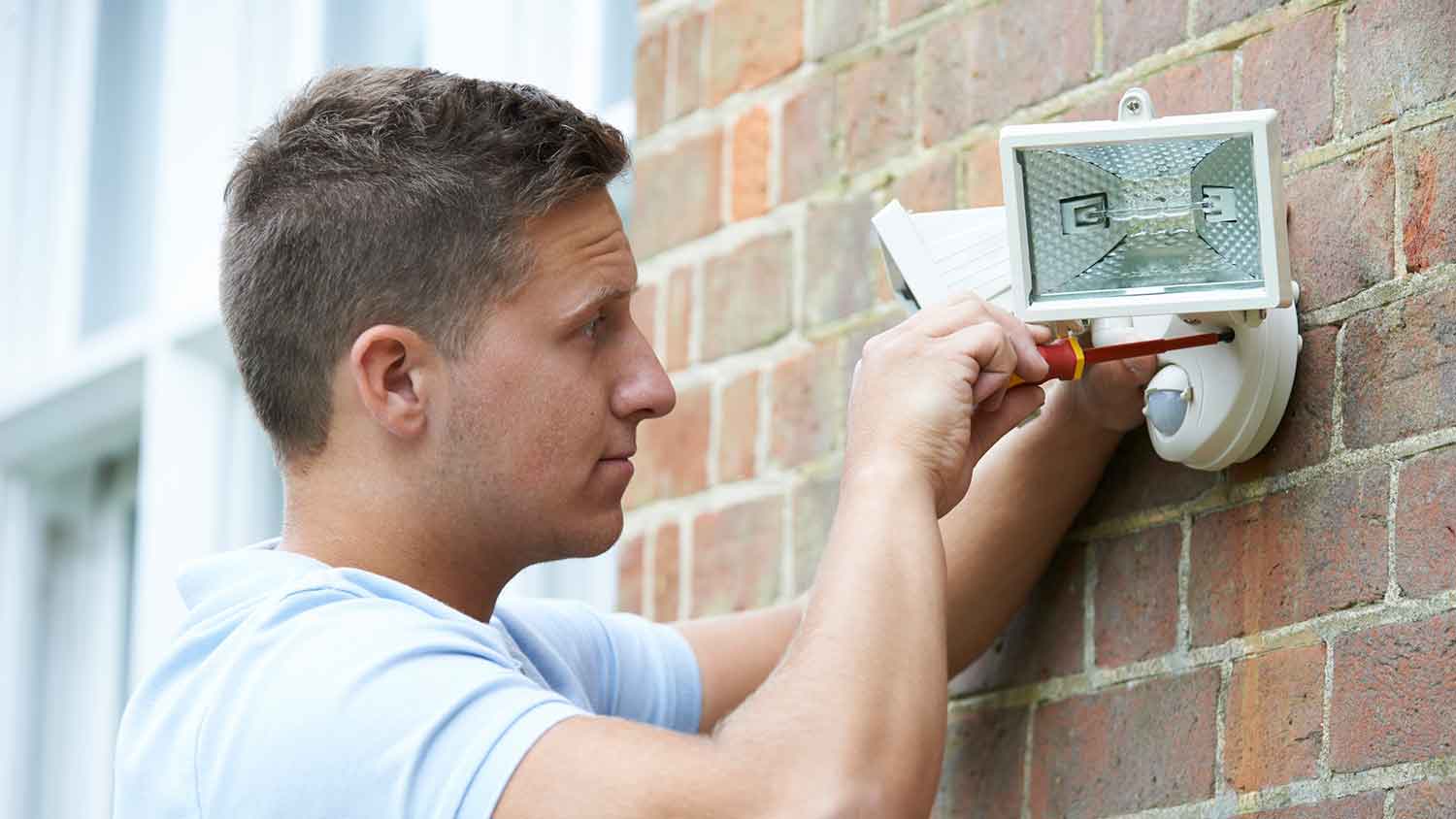 Man installing motion sensor security light