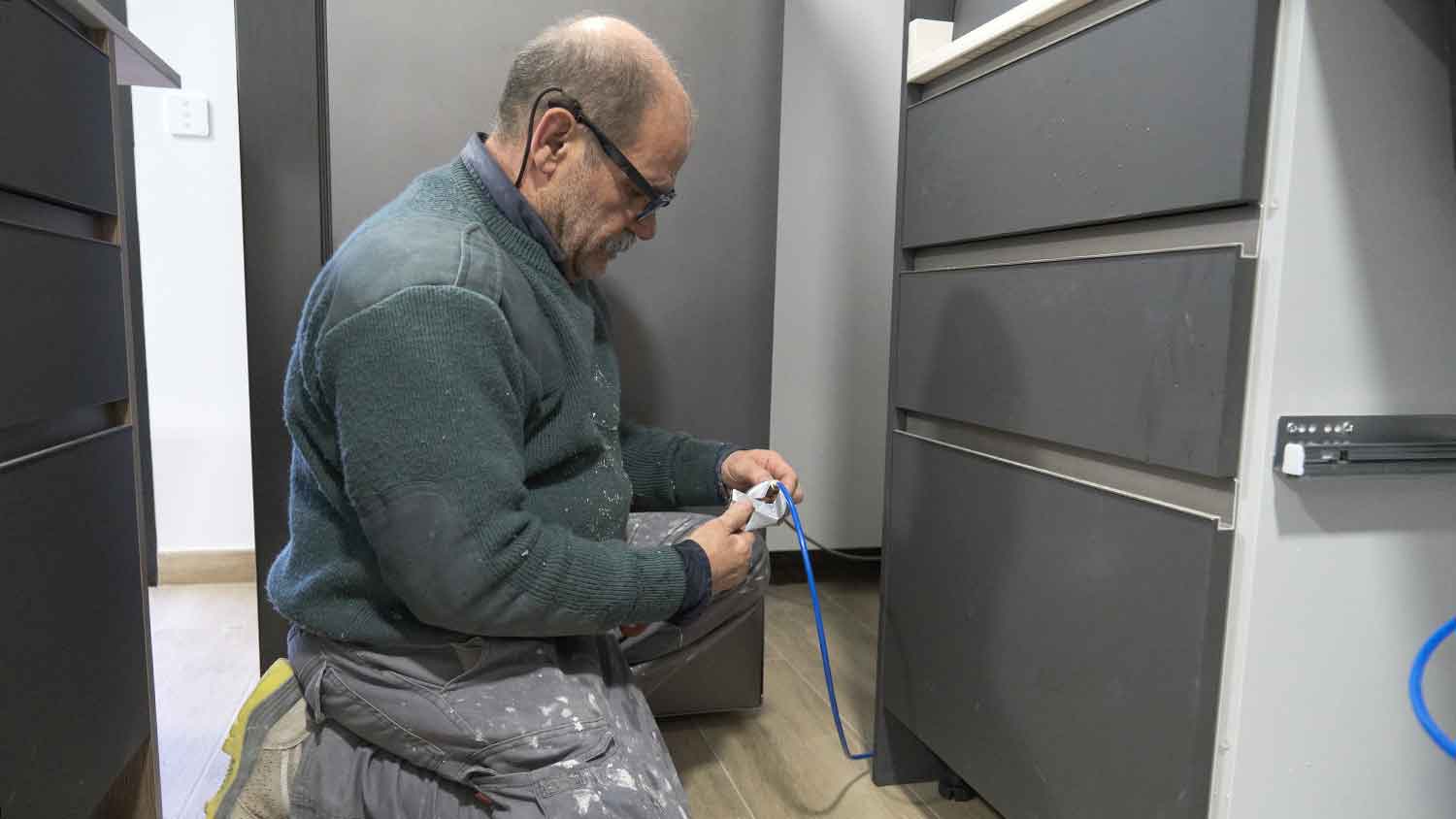 Plumber installing water line for refrigerator