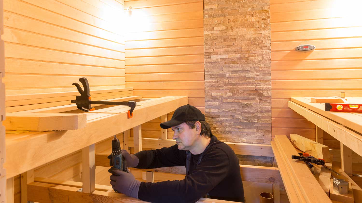 man installing sauna bench