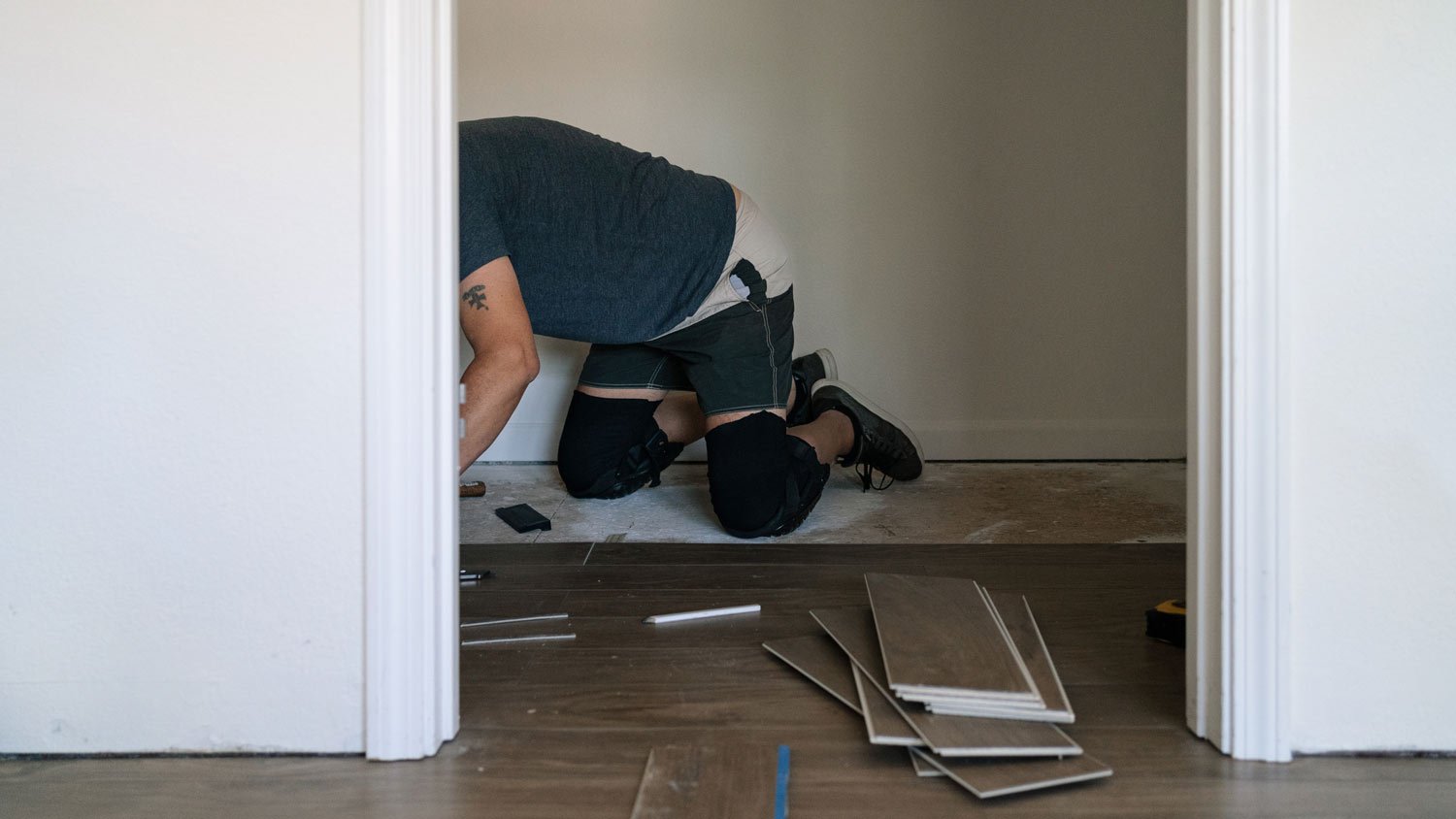 man installing wood floor in home