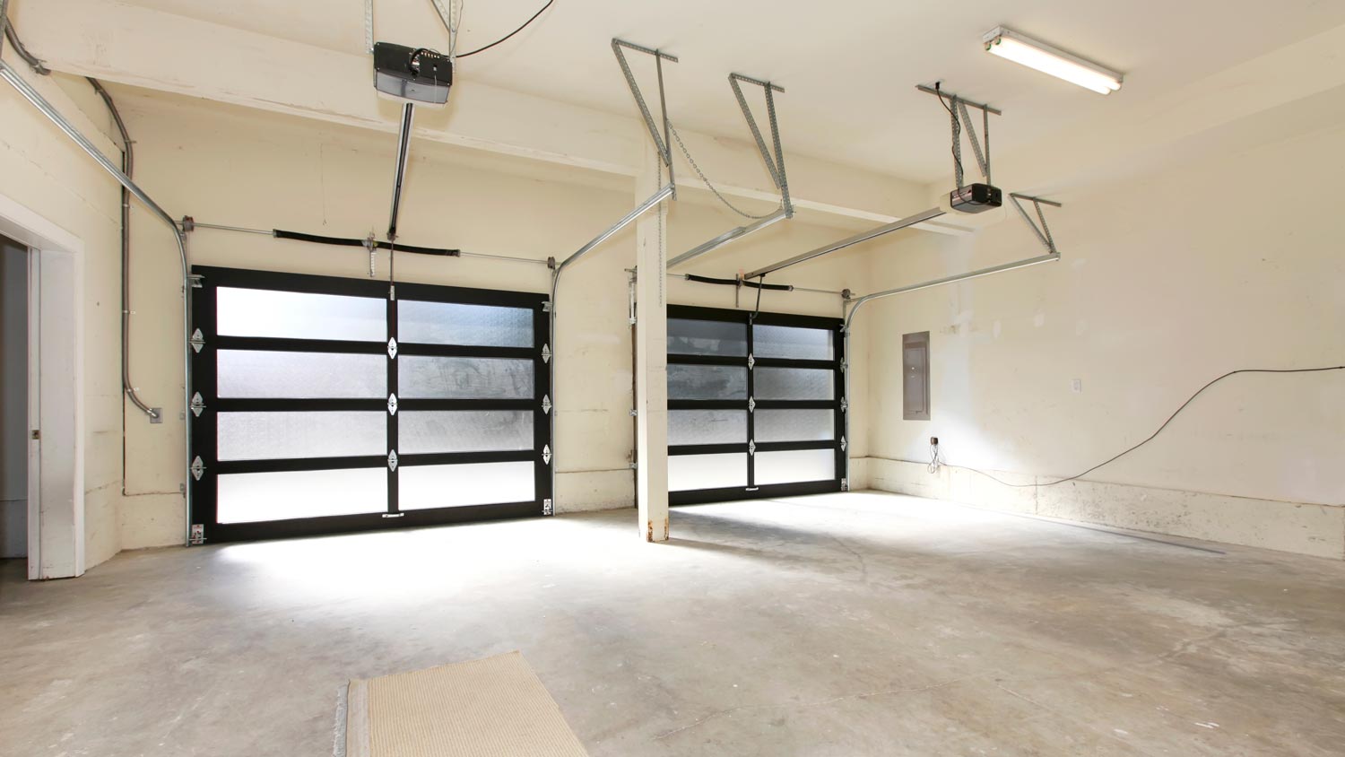 The interior of an empty double garage with glass doors