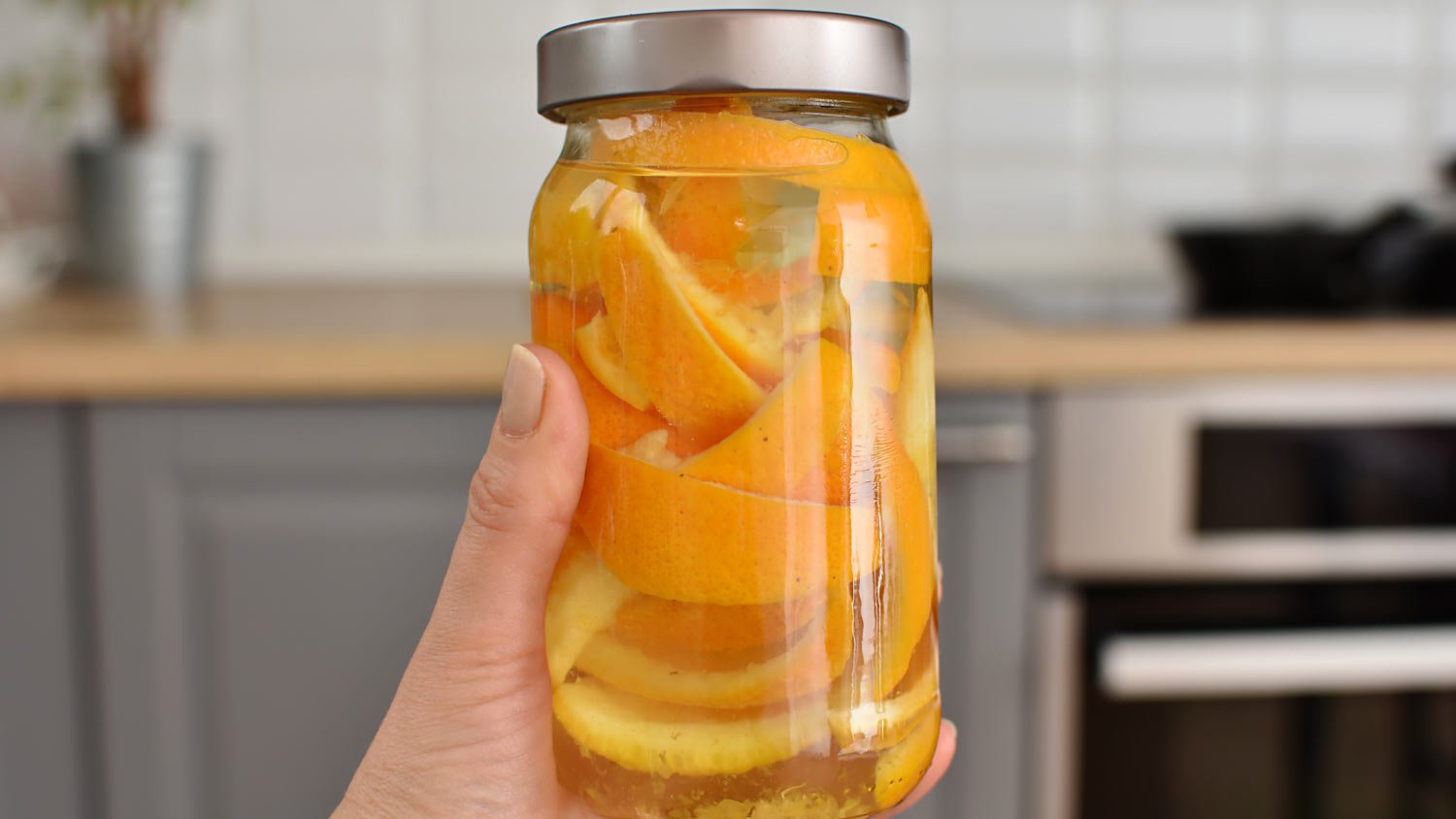 woman holding jar with orange peel 