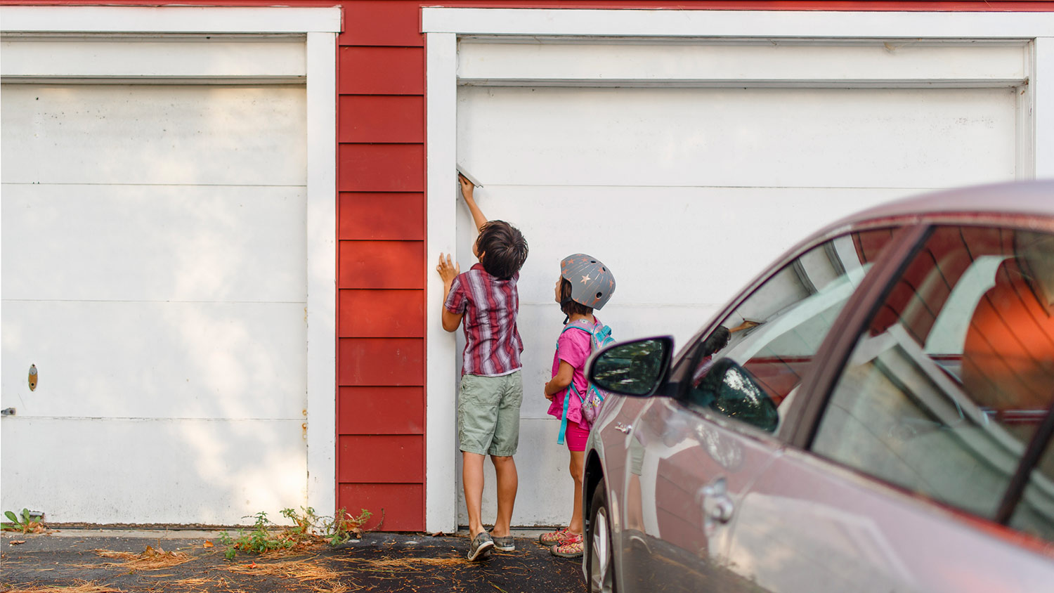 Two children press keypad to enter garage