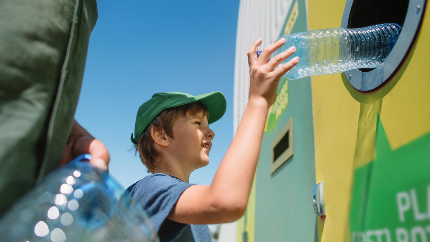 A kid recycling a plastic bottle