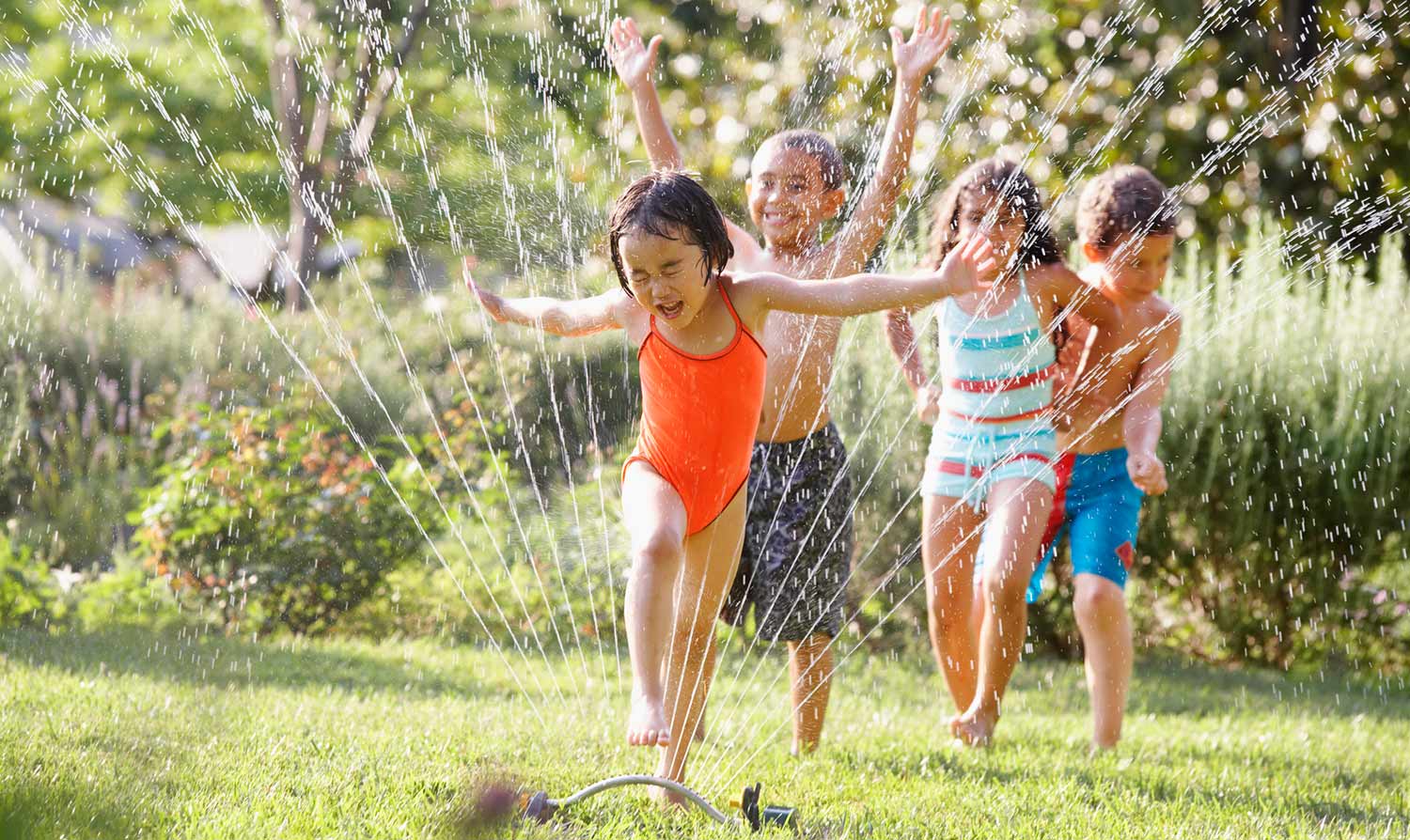 Kids playing in water sprinkler