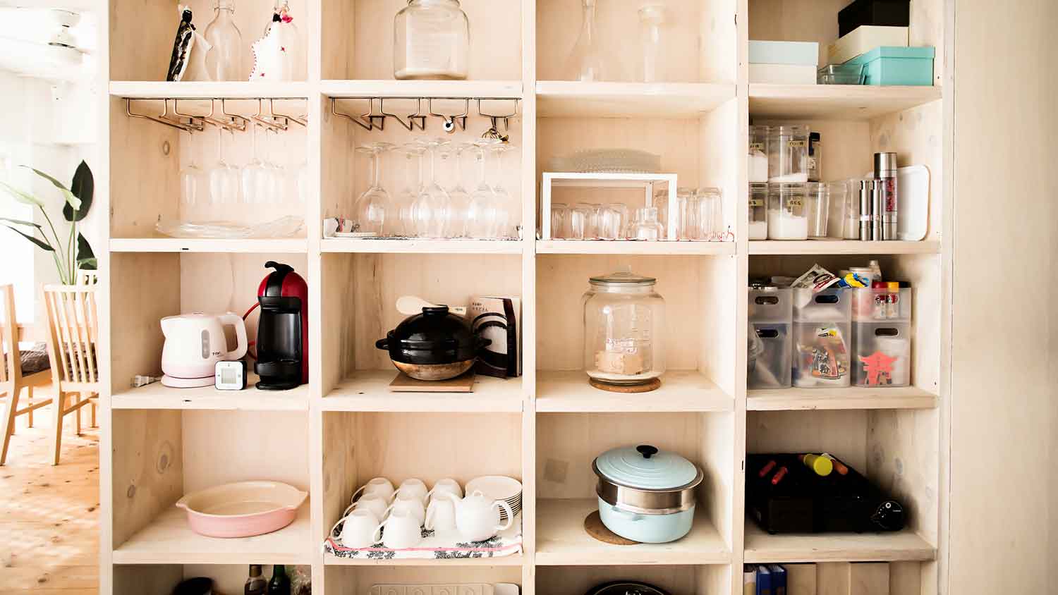 Wooden storage shelf with kitchen appliances and utensils