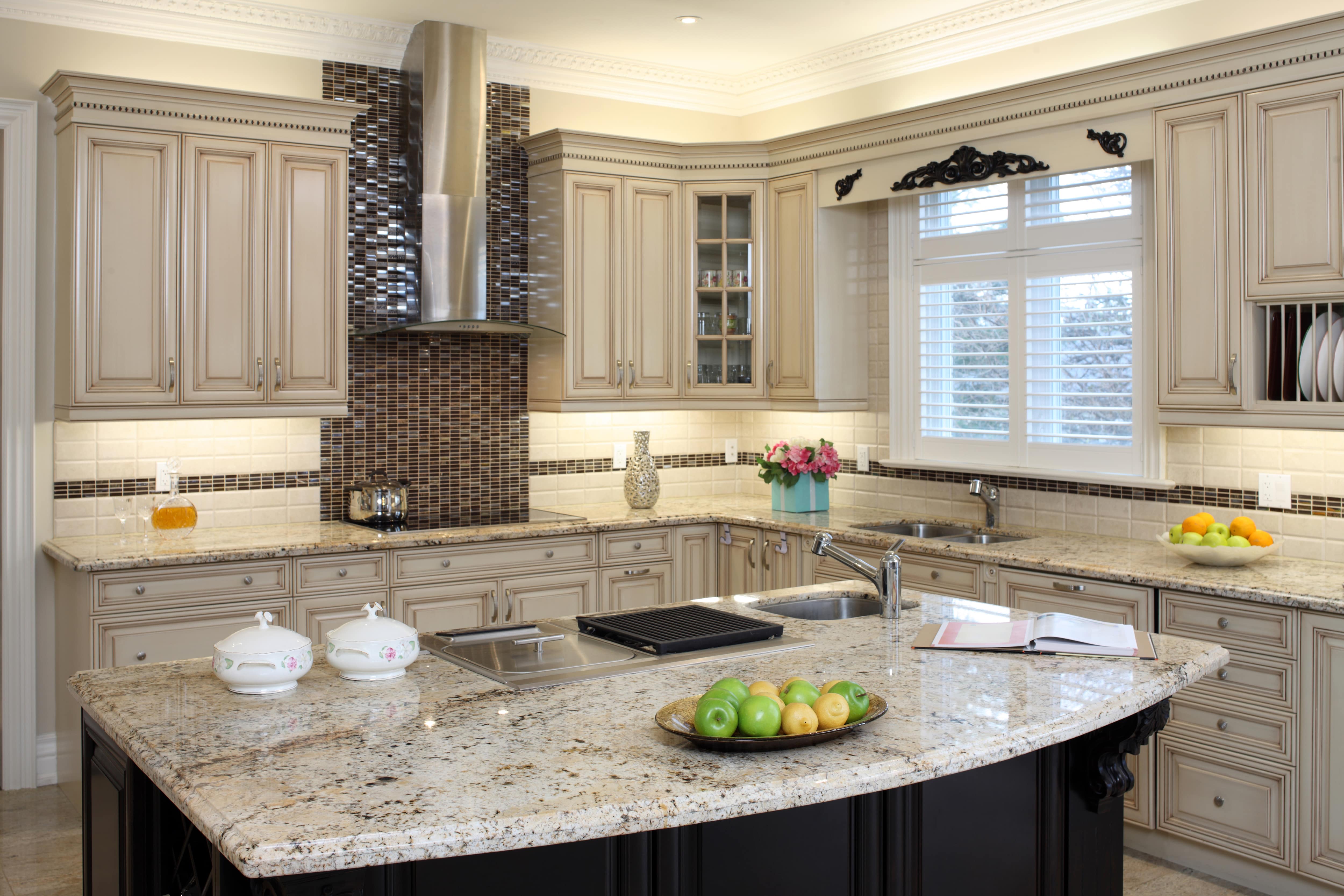 A black and white kitchen with custom backsplash and range hood