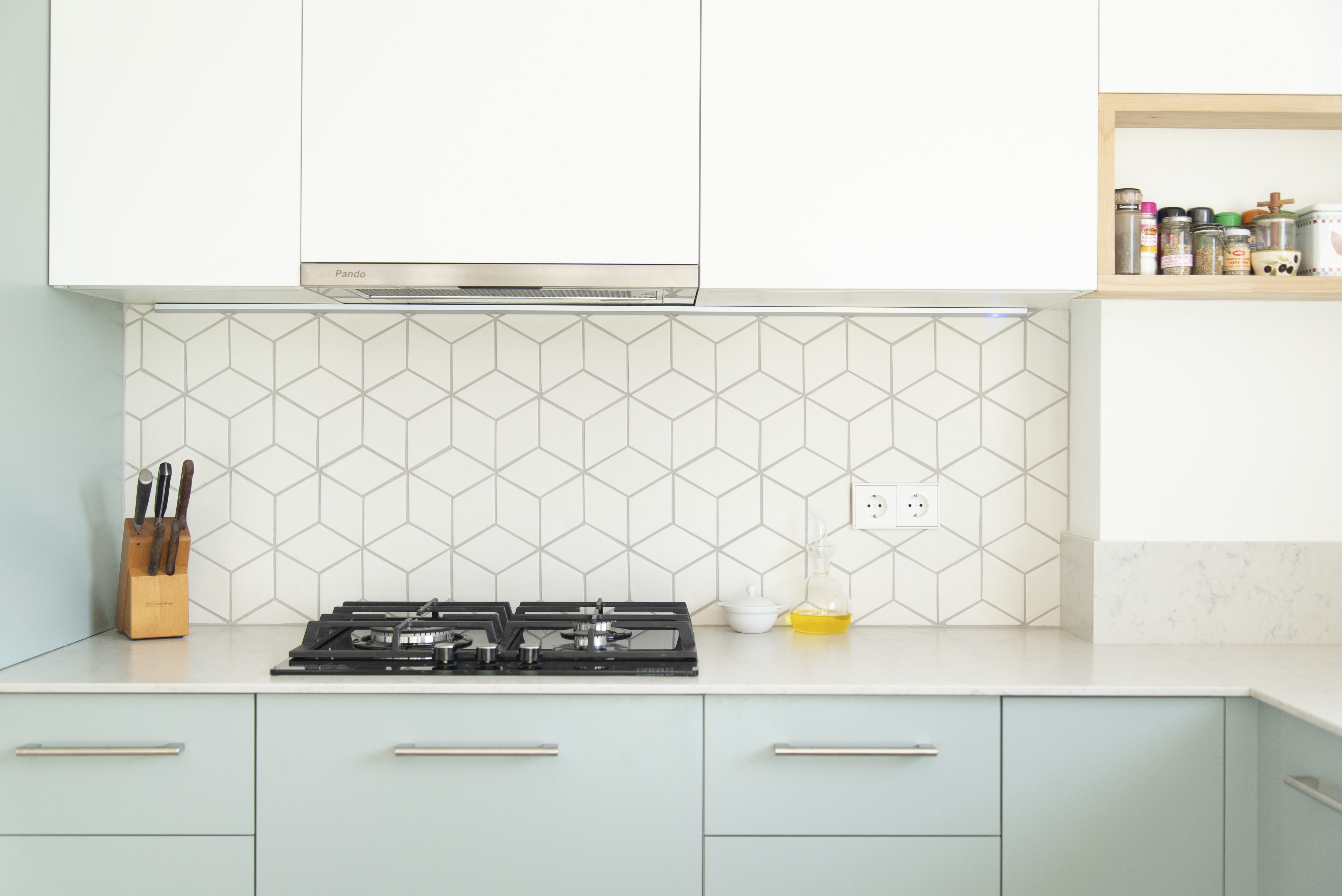 Geometric kitchen backsplash against white and blue cabinets