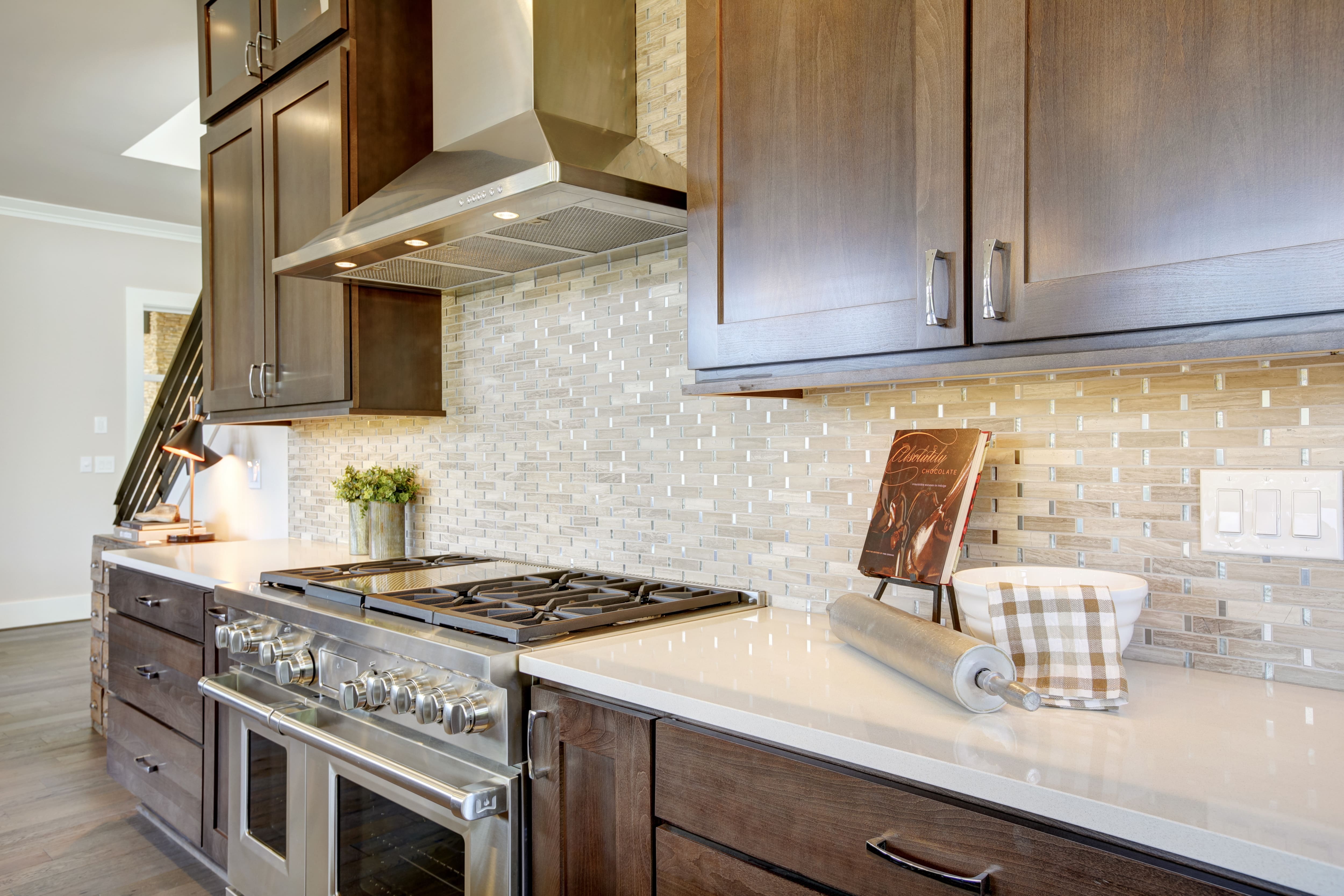 Brass kitchen hood, marble slab backsplash, navy blue kitchen