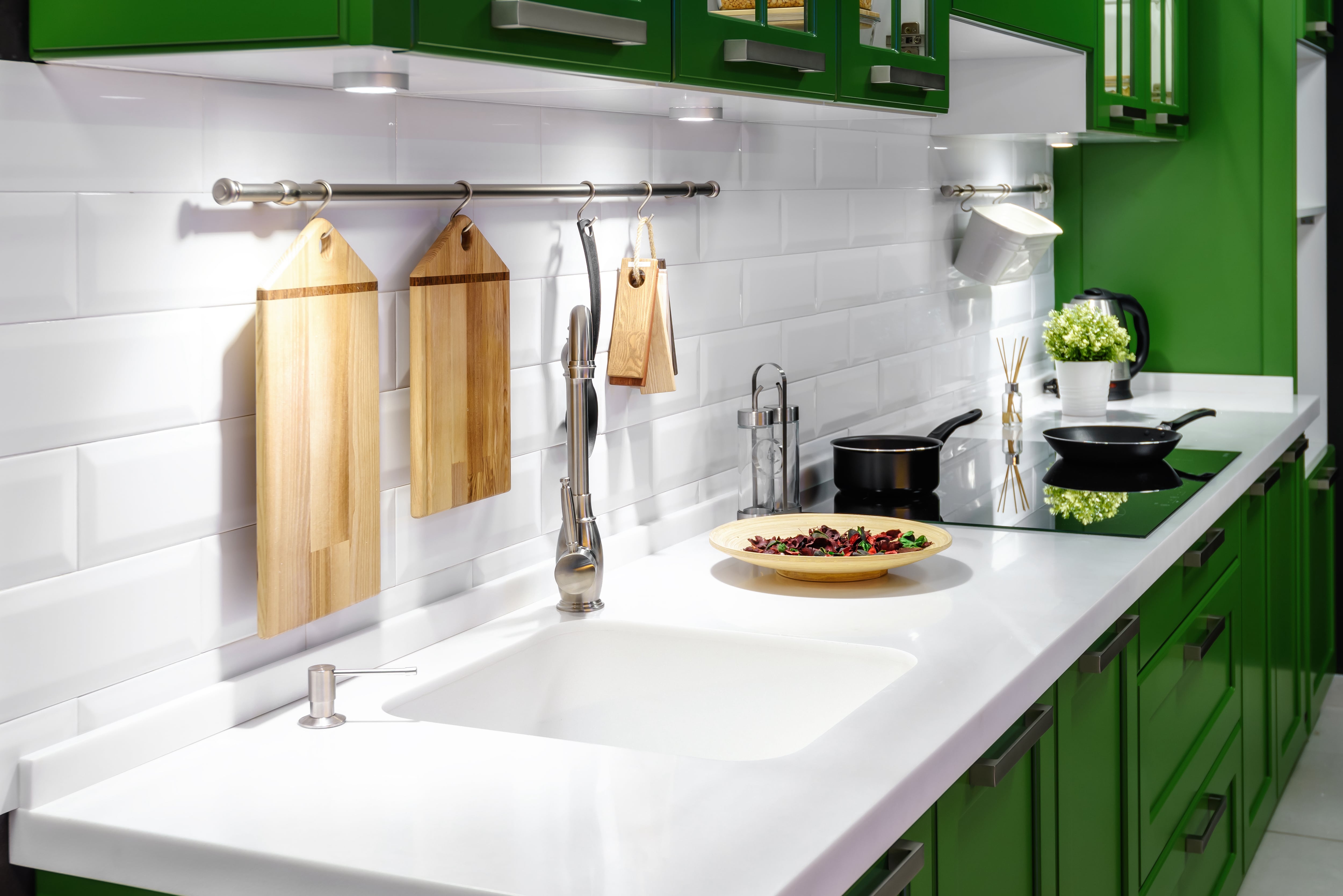 Kelly green kitchen cabinets with white acrylic countertops and built-in kitchen sink