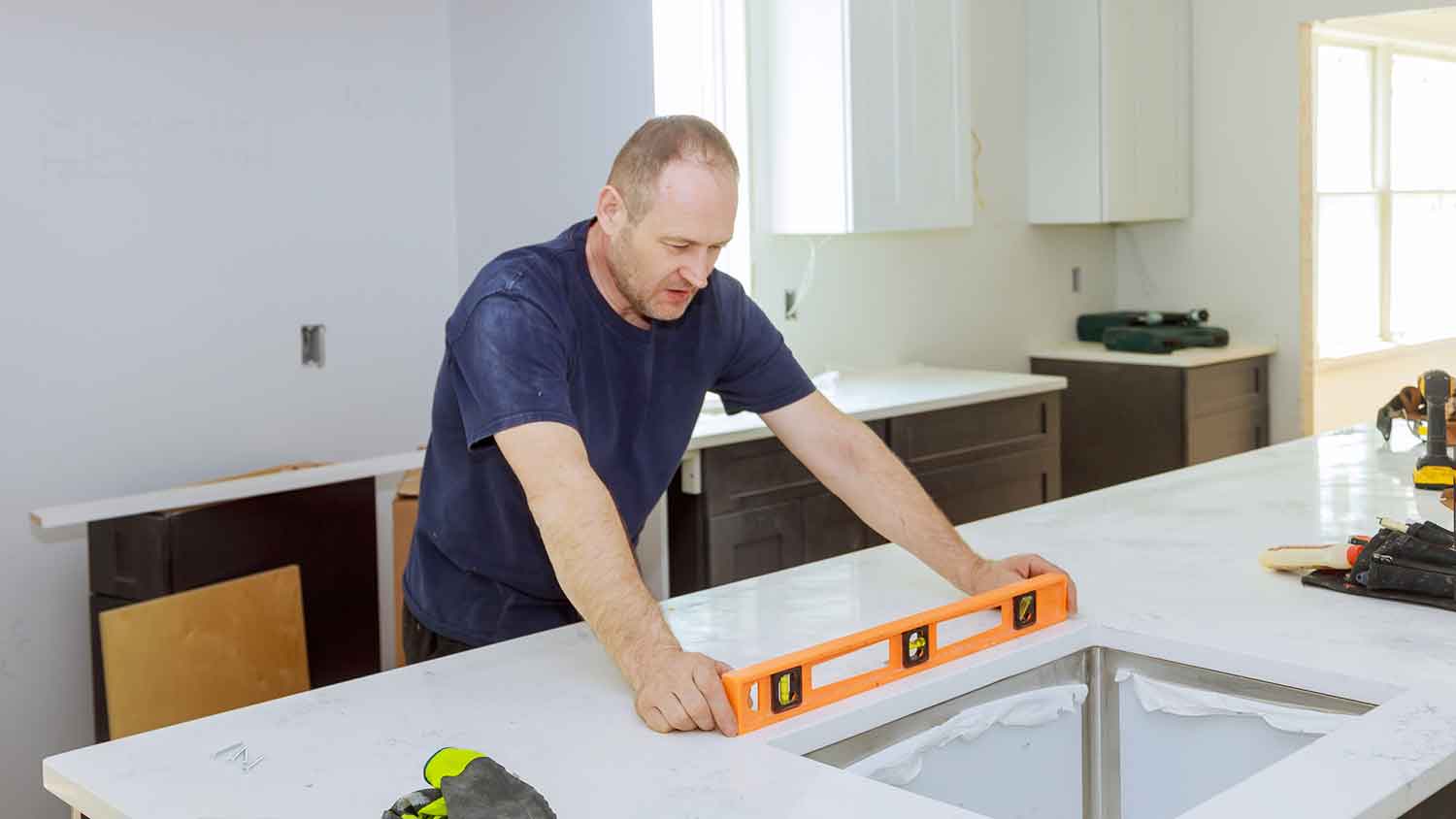 Man using leveling tool to install kitchen countertop