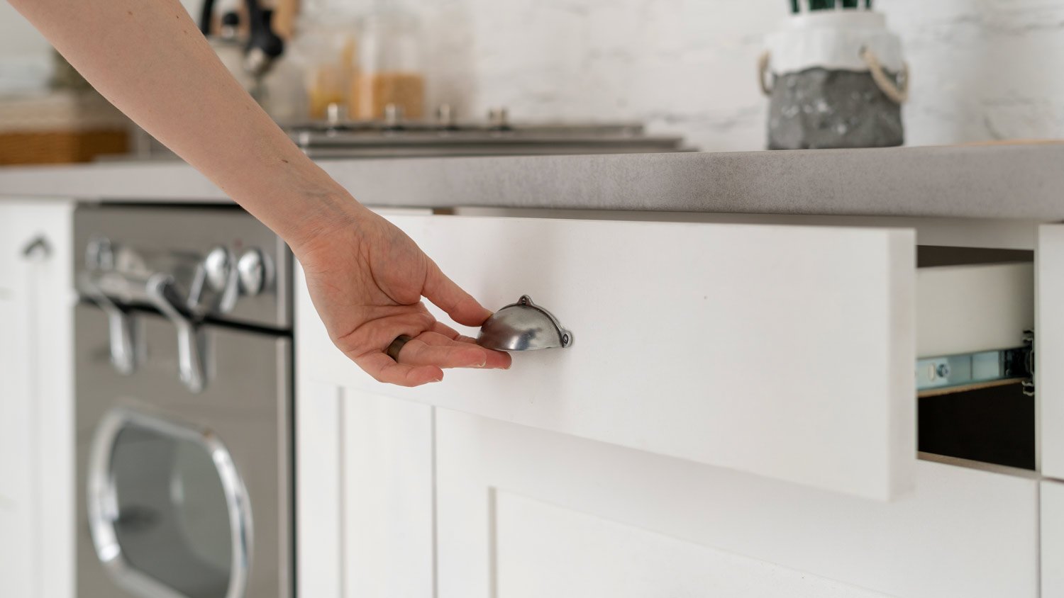 woman grabbing handle of kitchen drawer