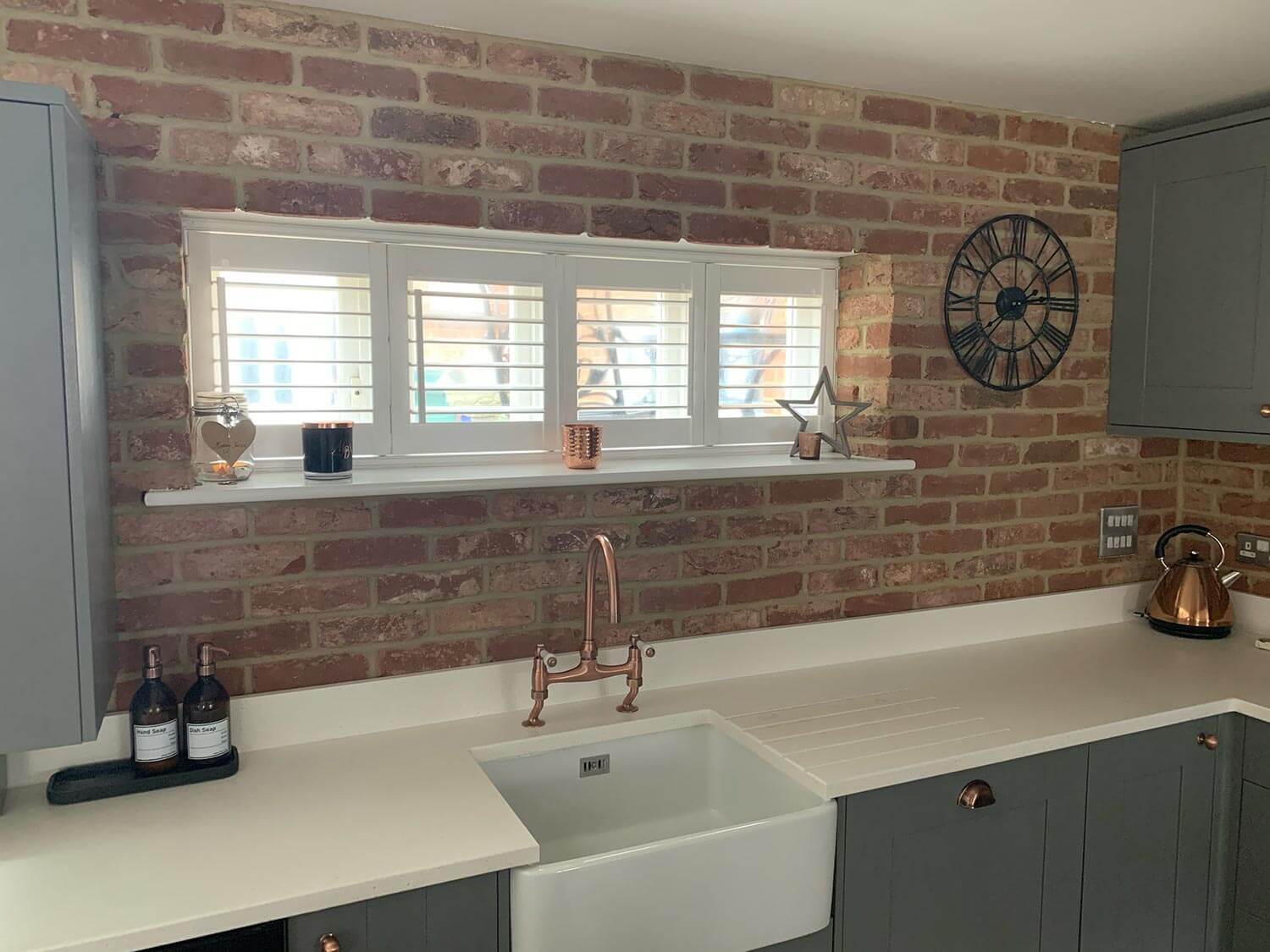 A kitchen with an exposed brick wall