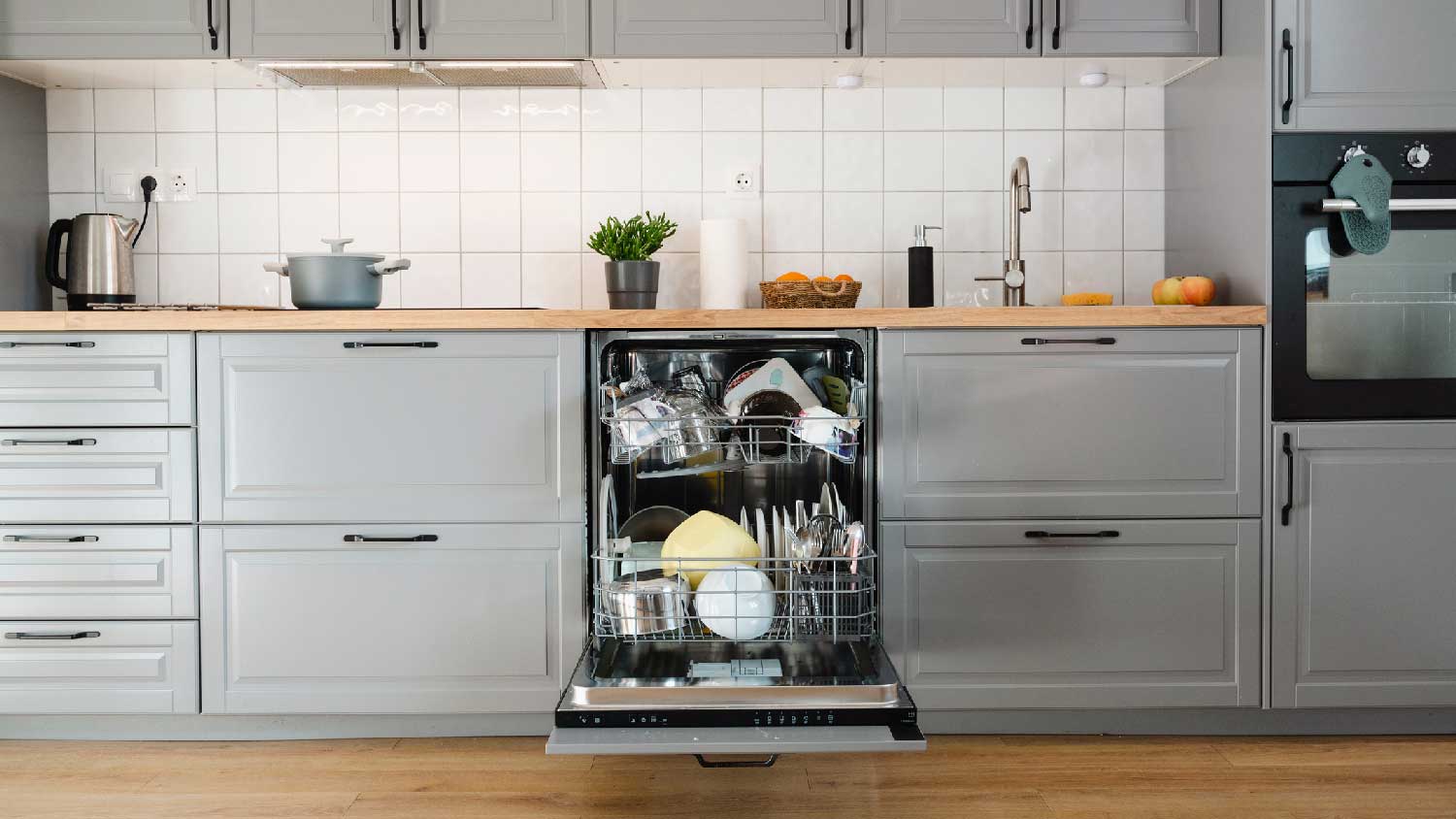 A kitchen with a full dishwasher