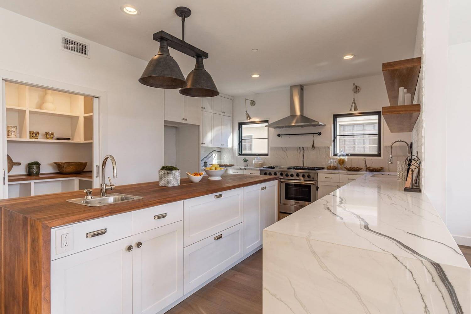 A kitchen with an island and dark frame windows