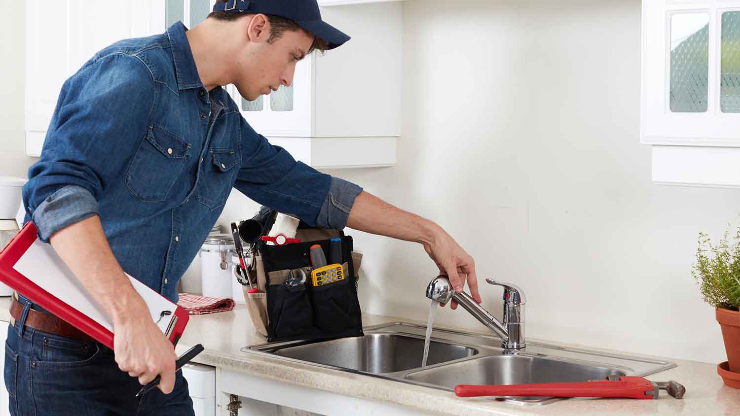 Plumber inspecting kitchen sink plumbing