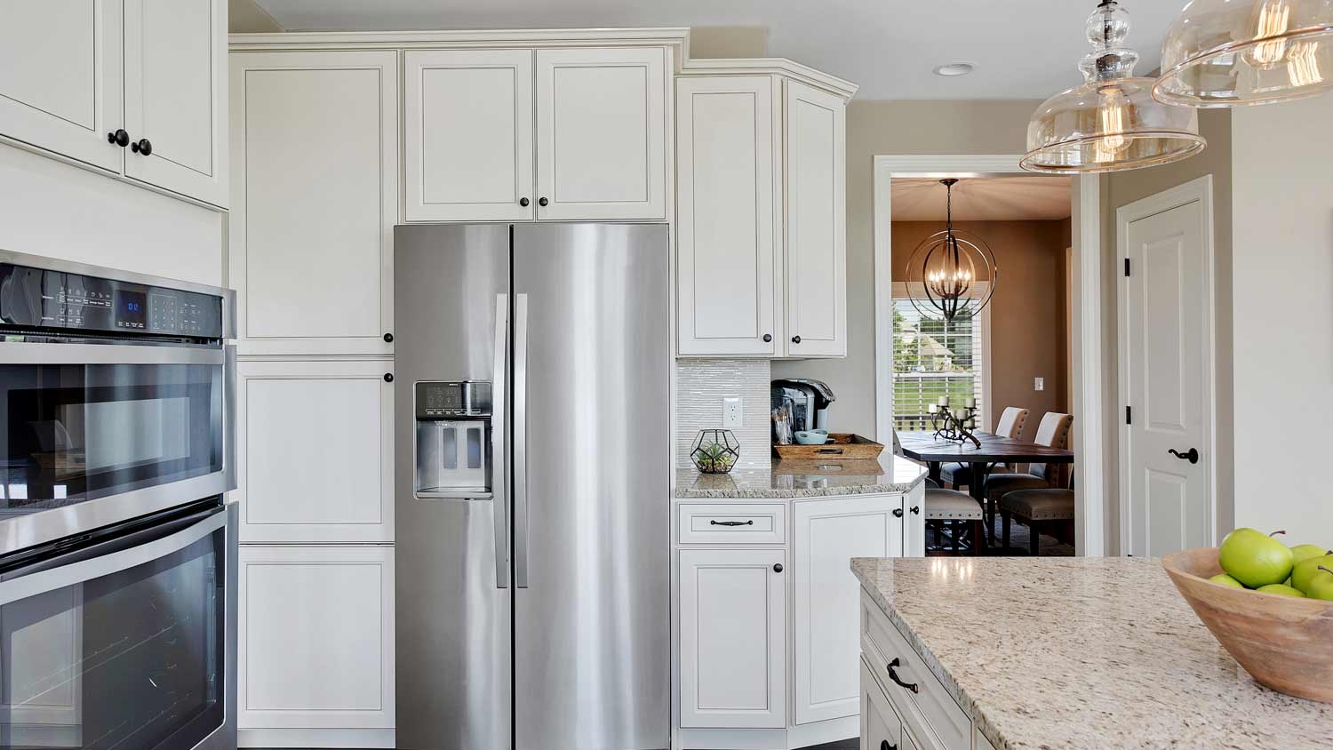 white kitchen with silver refrigerator 