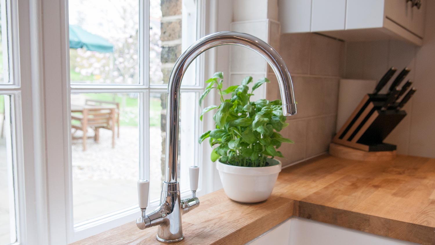 A kitchen sink with a plant pot 