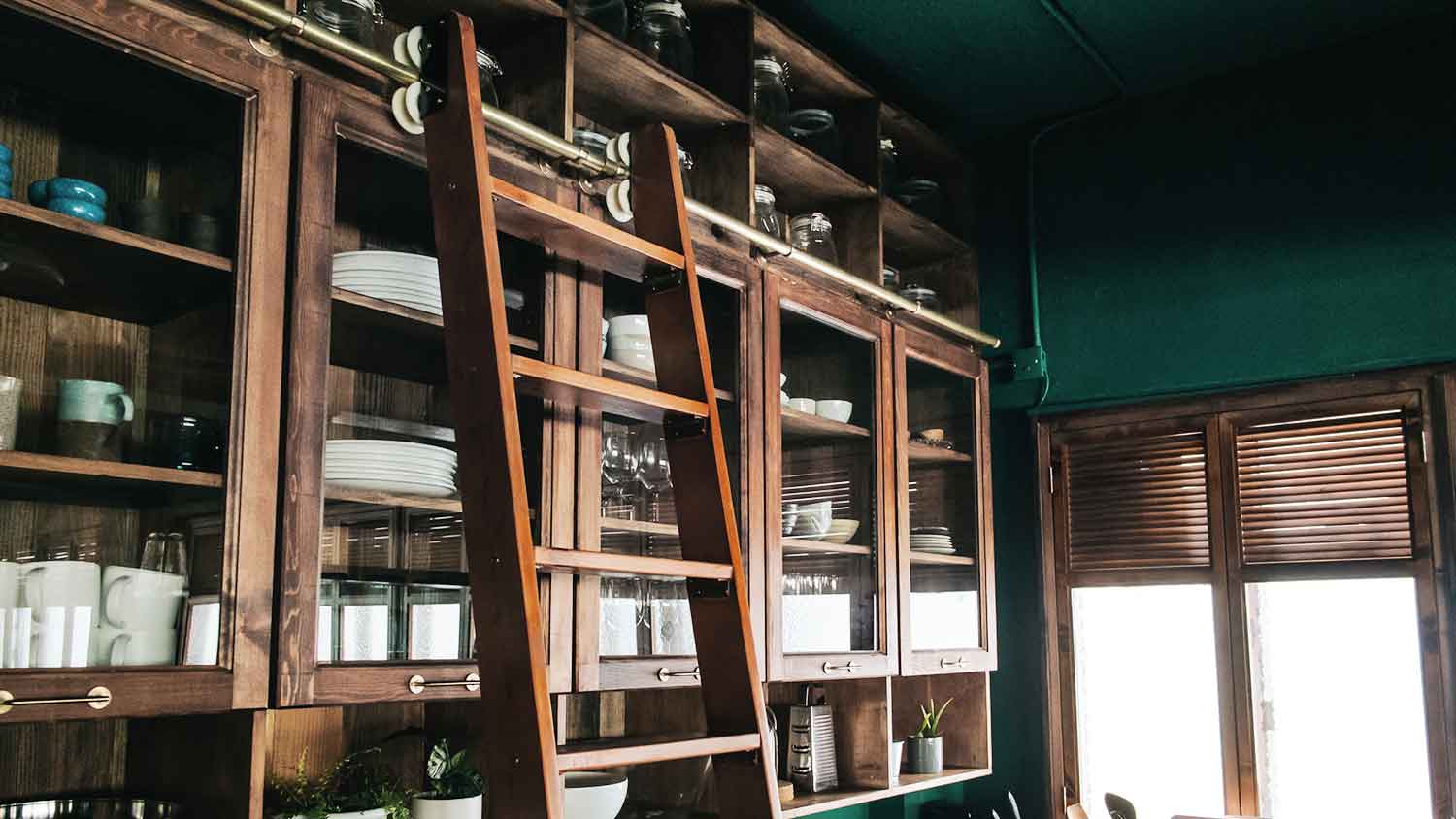 Kitchen with brown wooden cabinets and a sliding ladder