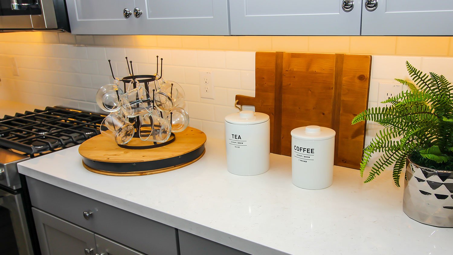 A view of mugs hanging on a turntable in a kitchen