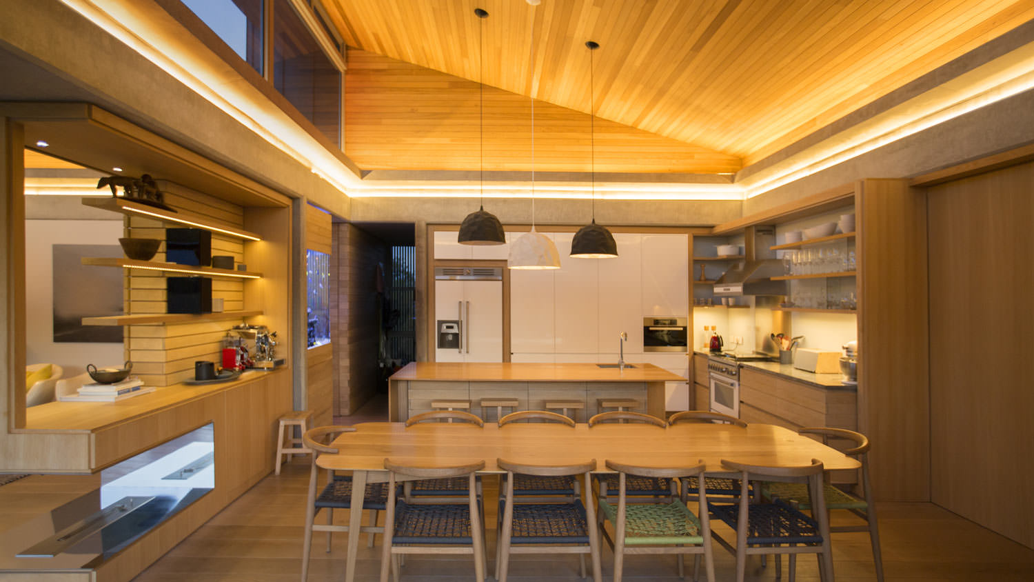 A kitchen with wooden vaulted ceiling at night