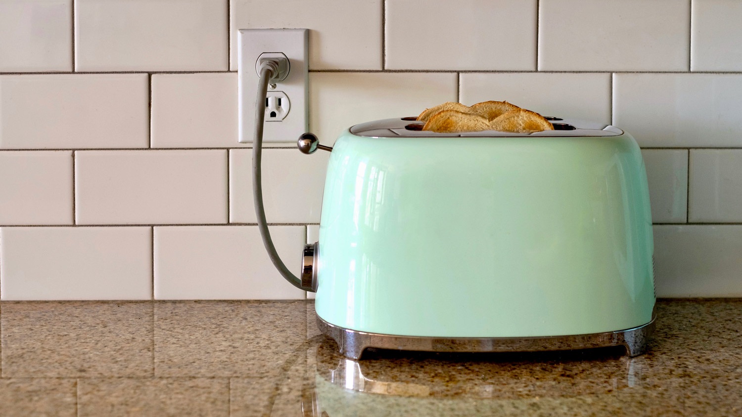 Green toaster plugged into outlet