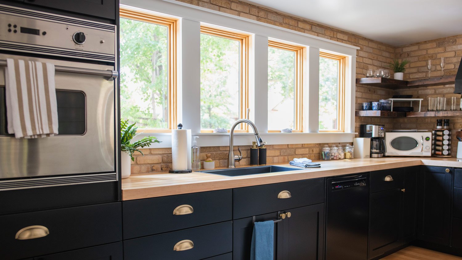 View of home kitchen showing oven and counter top with daylight shining through windows