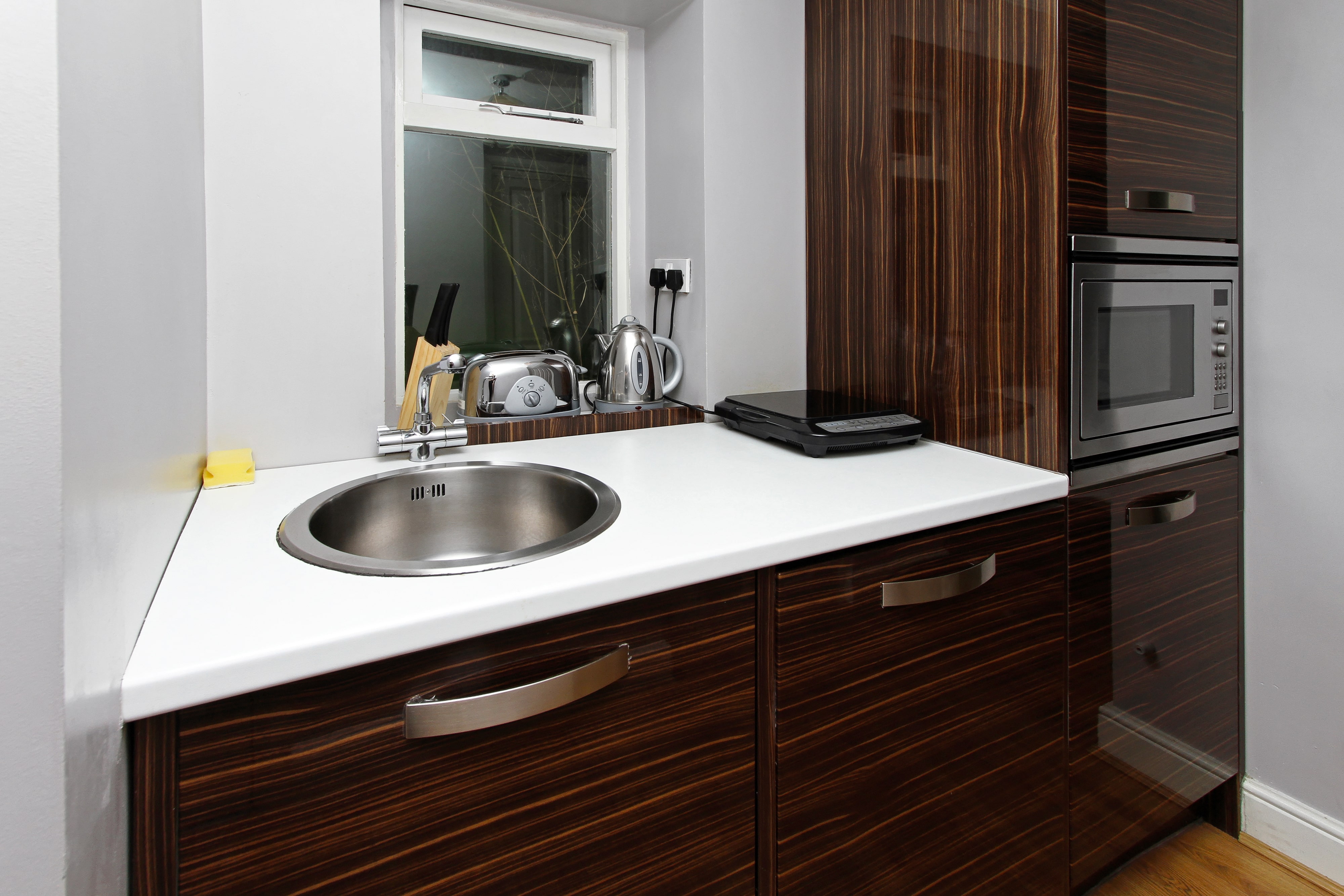 High gloss wooden cabinetry in modern kitchenette