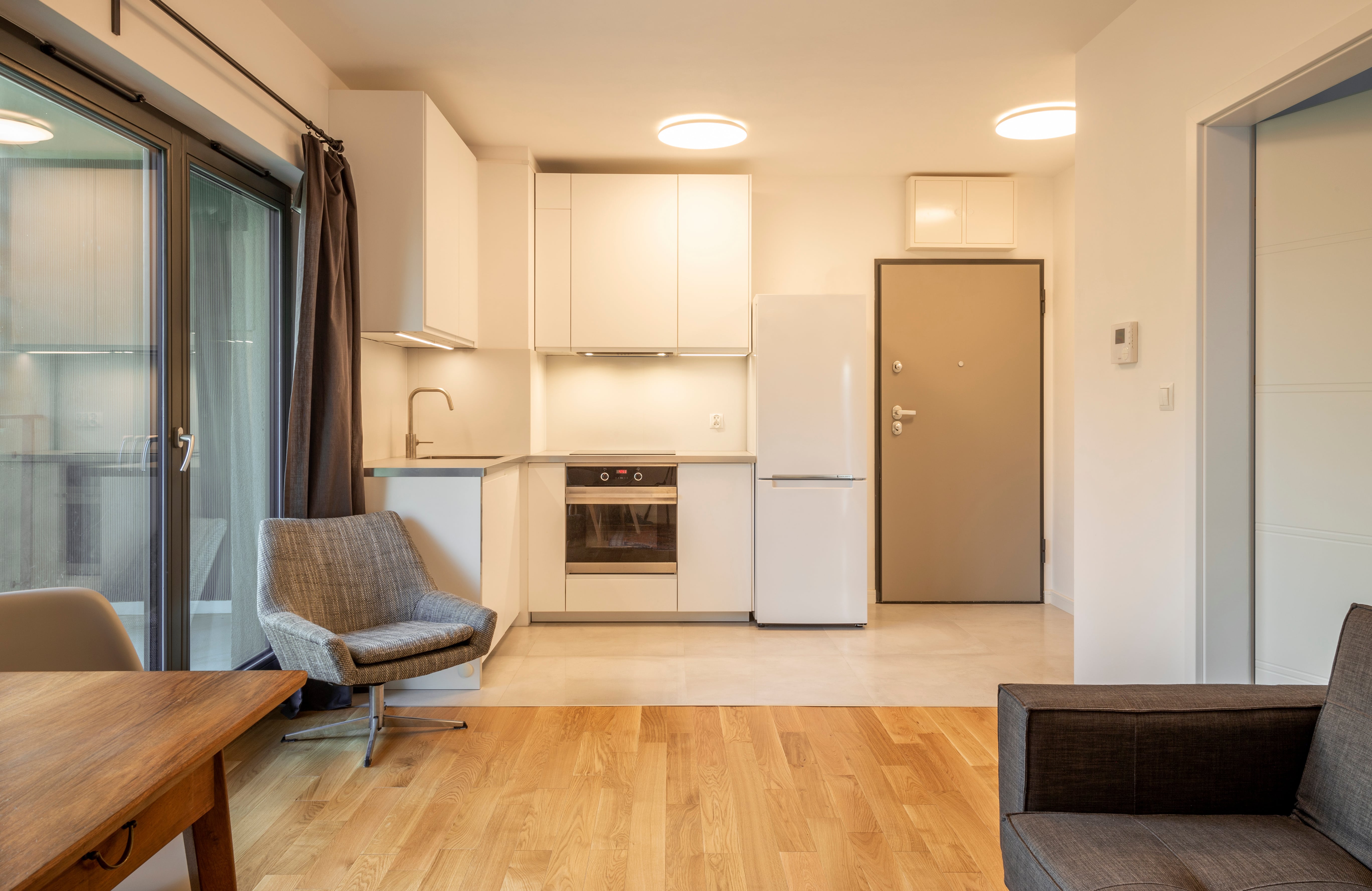 Minimalist kitchenette area with white modern cabinetry