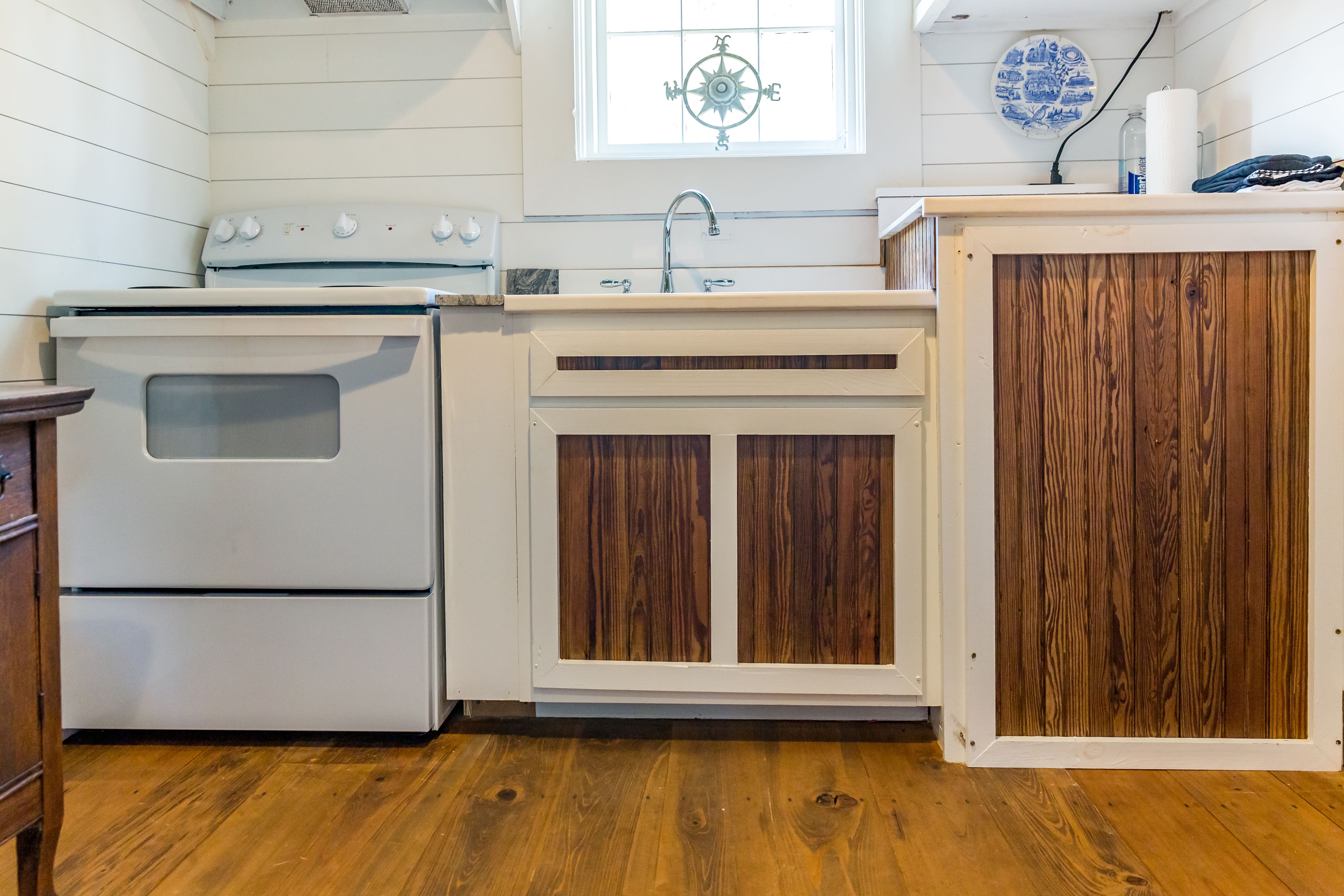 Kitchenette featuring mixed-material cabinetry with shiplap walls