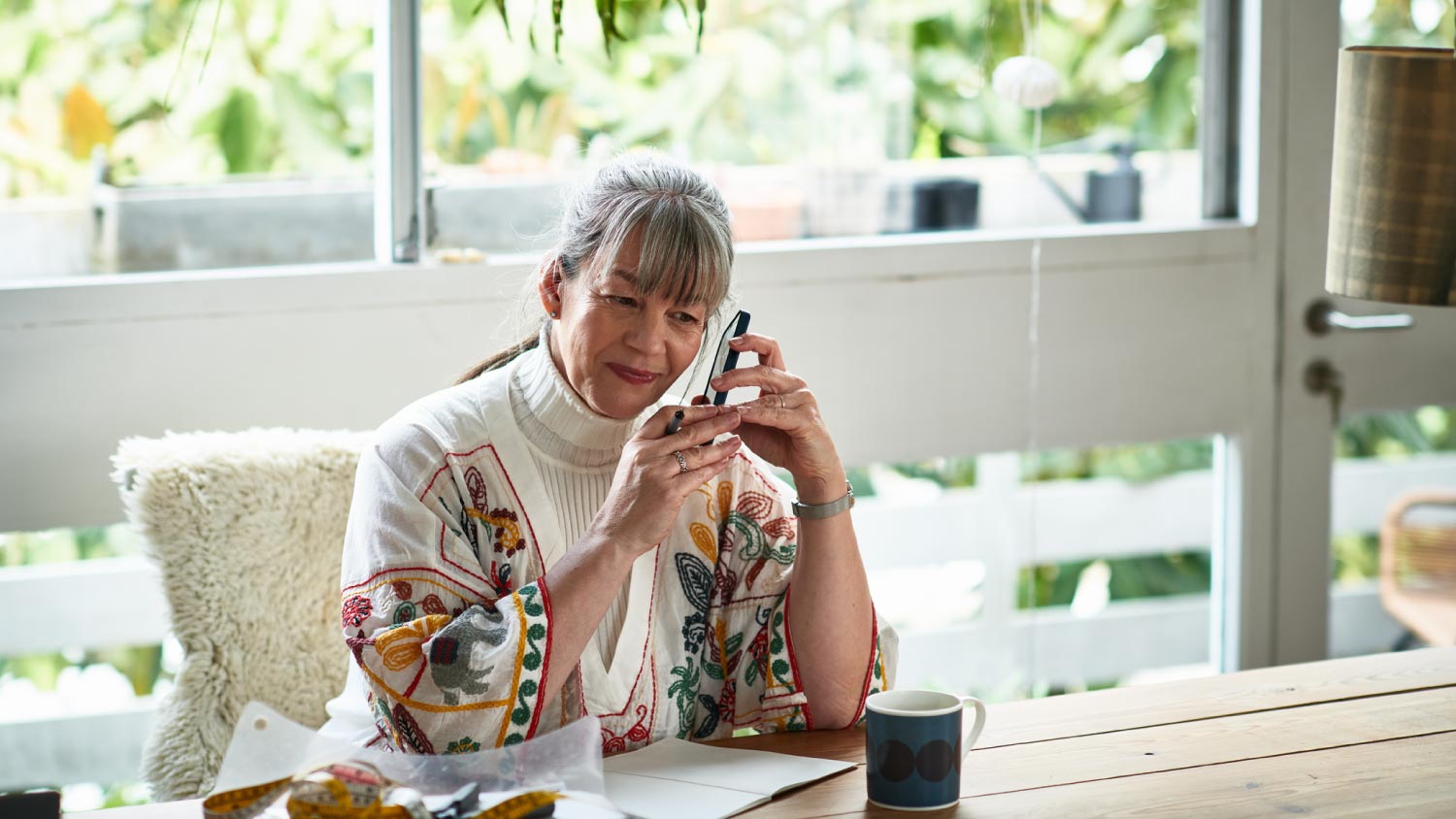 An old lady holding mobile phone and listening to messag