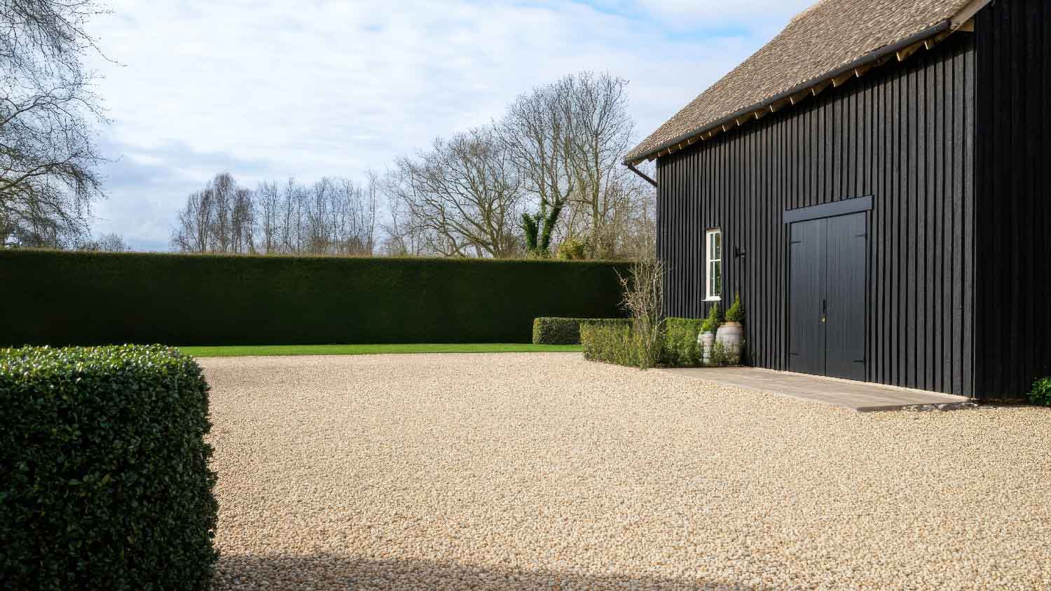 A large barn with a resin driveway