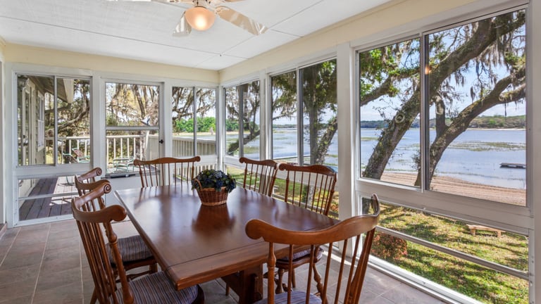 Large enclosed porch with dining table and chairs