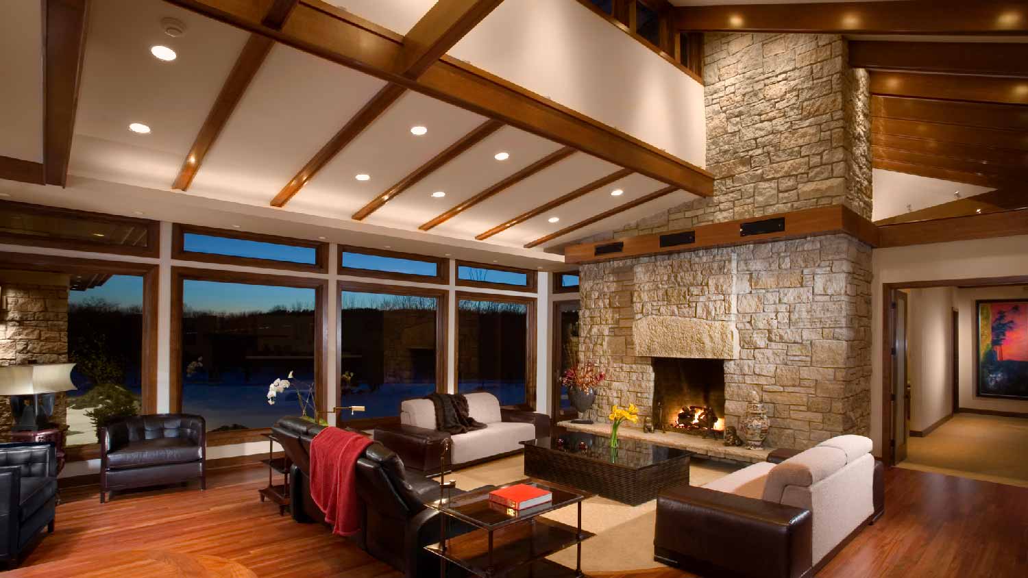 A large living room with recessed lights and a stone fireplace